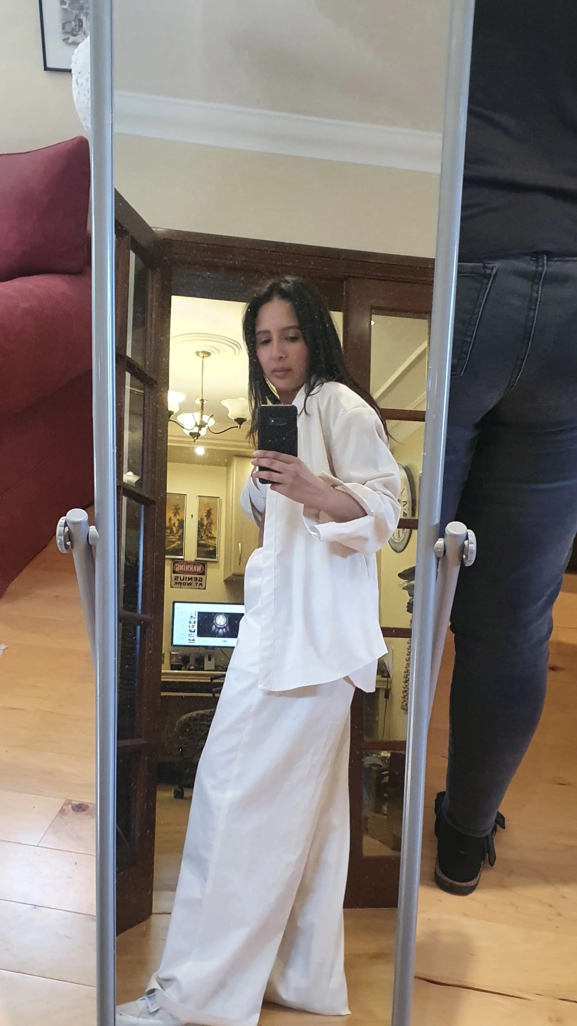 Women with dark hair fit testing a two piece sample set in fit lab takes selfie in the mirror