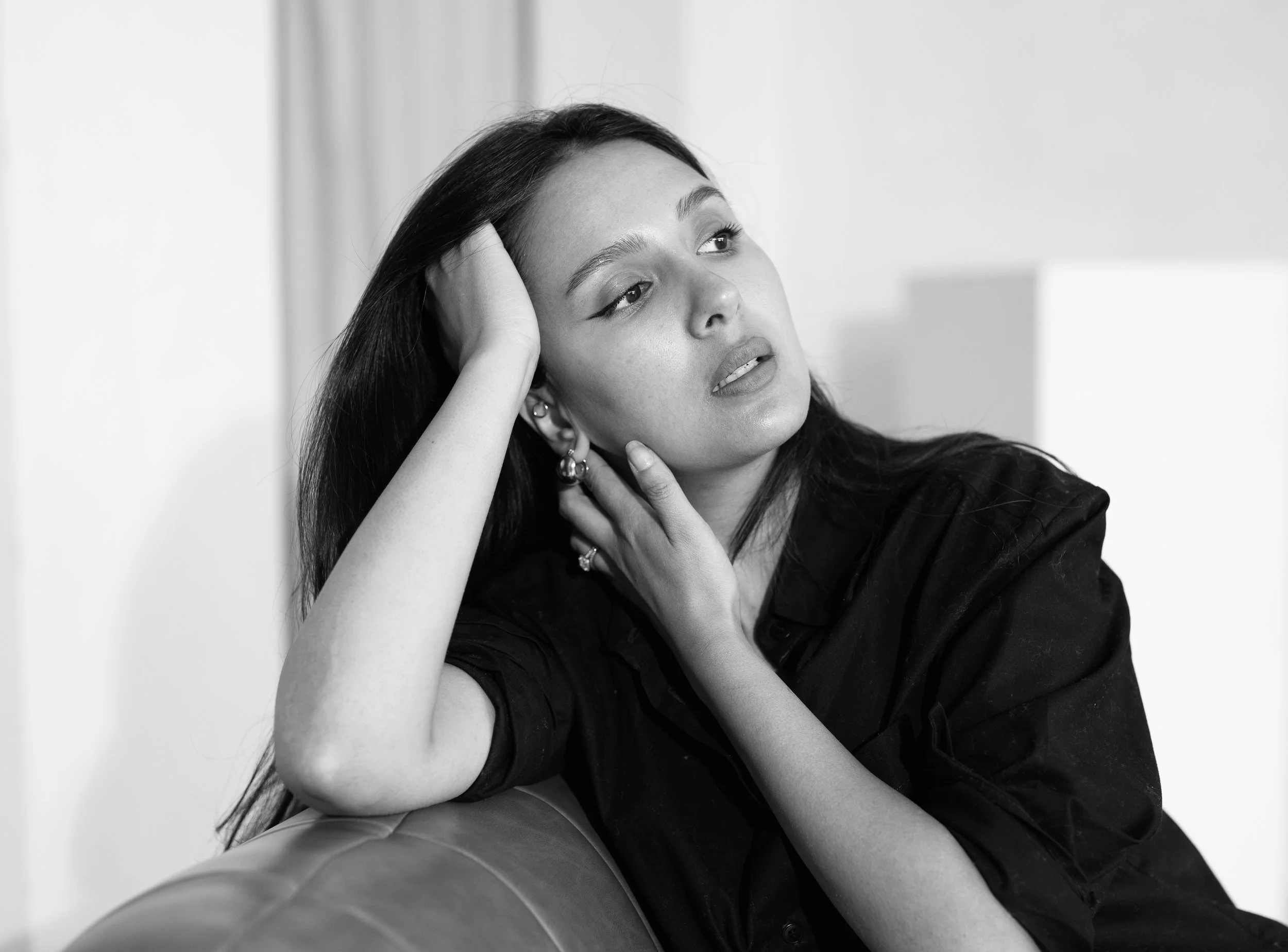 Founder Black and White Portrait Photo leaning on leather couch looking away in black shirt