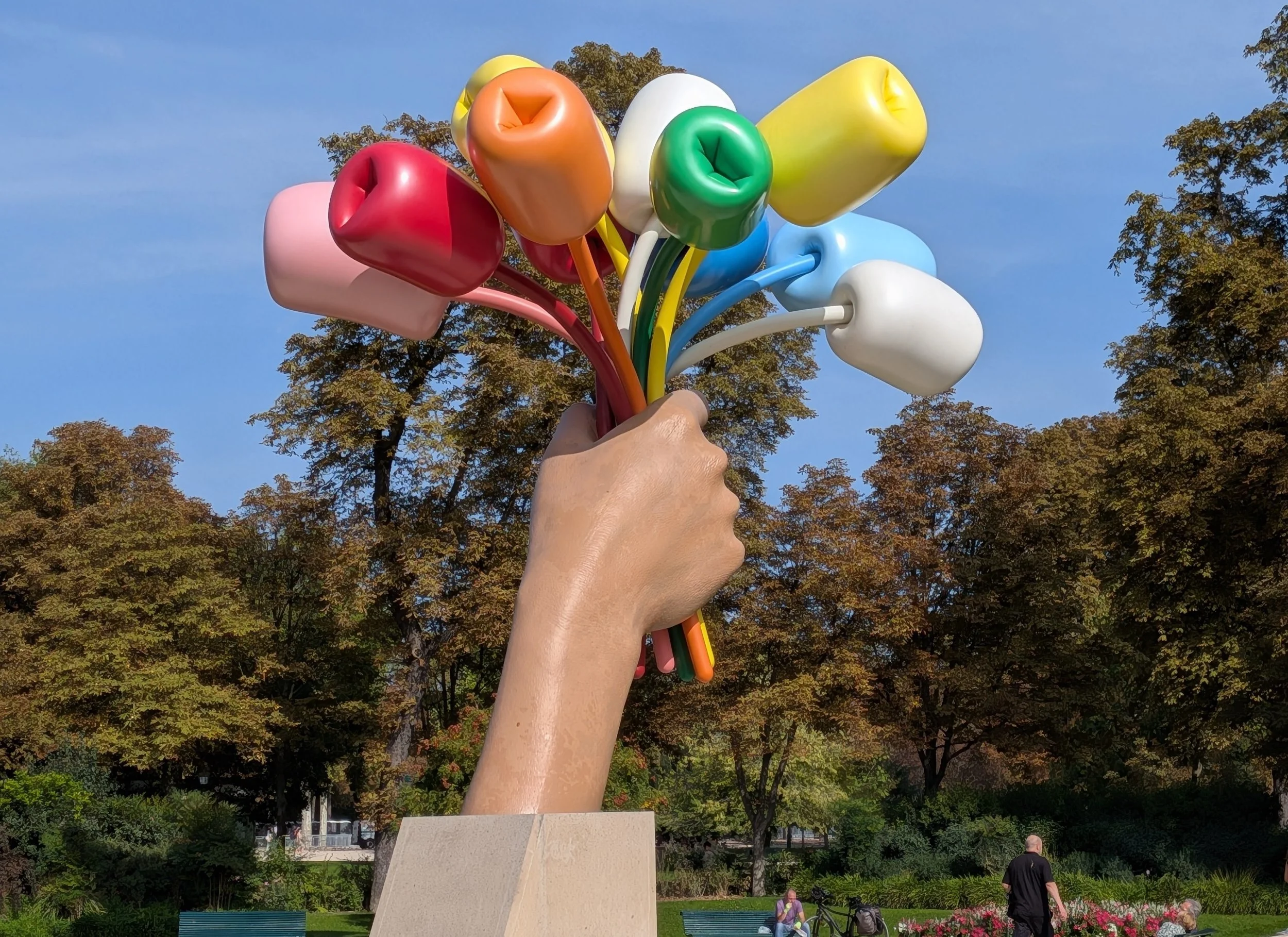 a statue of a hand holding a bouquet of flowers that look like ballons.