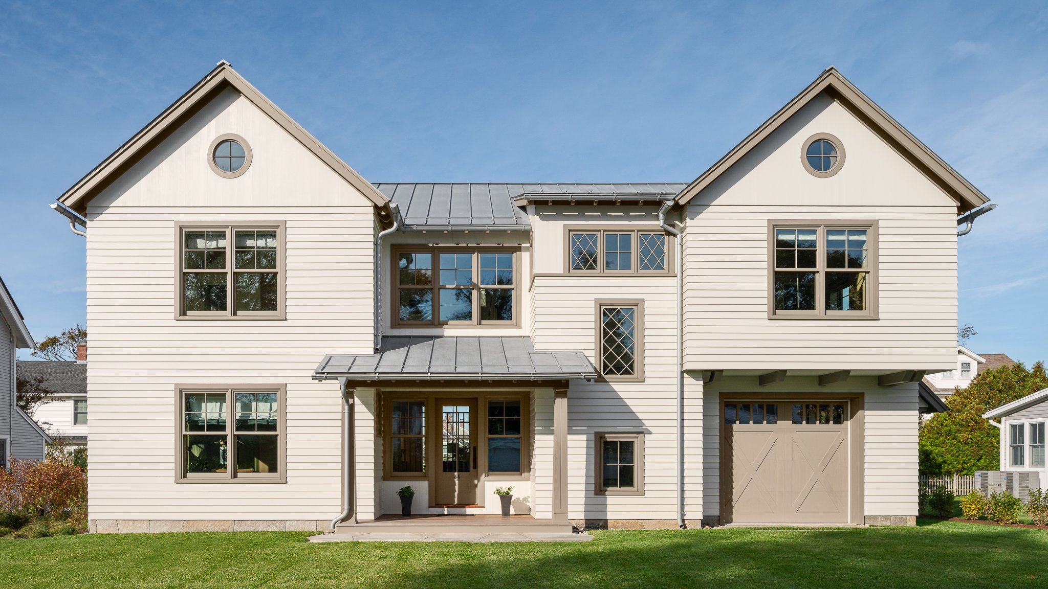 Front elevation of a guest house by Peggy Sullivan of Seabird Architects, with a metal roof and deep front porch in Madison, CT.
