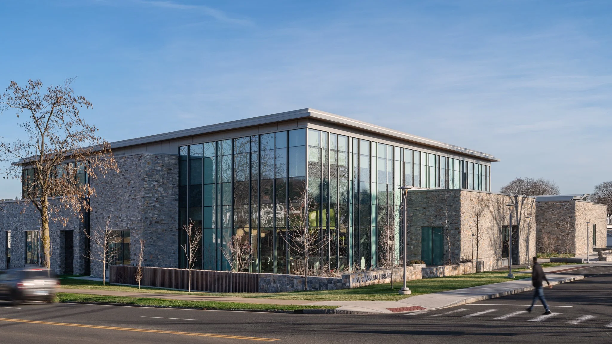 Street view of the glass curtain wall and stone facade.