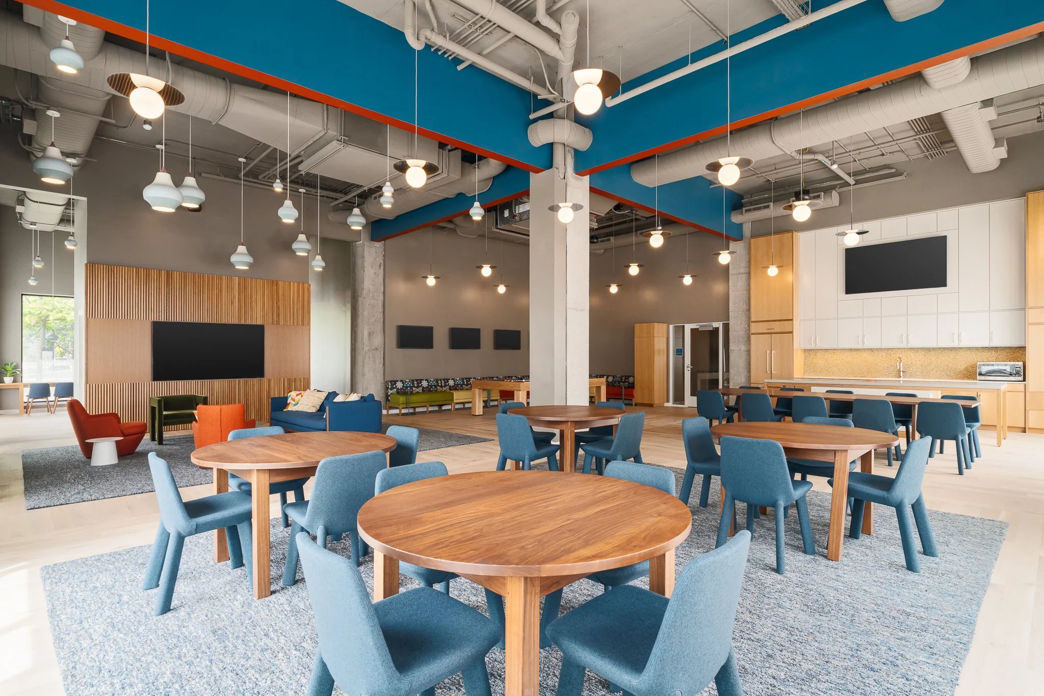 Resident common room with round tables and blue chairs.