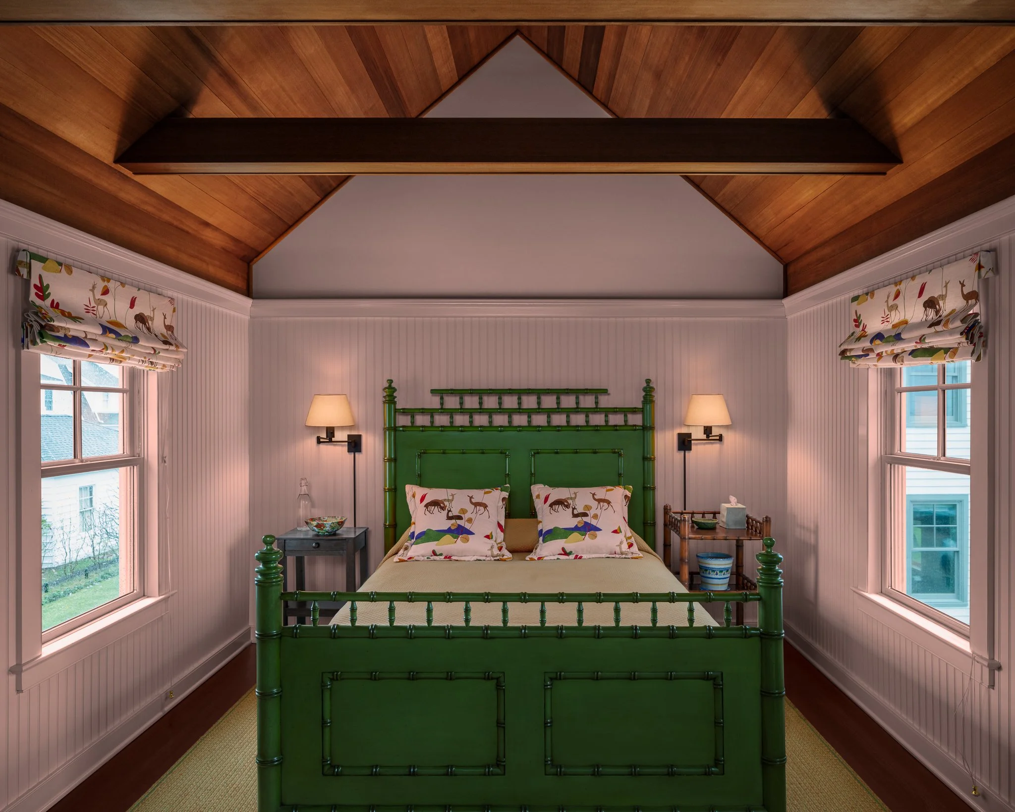 Shoreline home bedroom by Peggy Sullivan with a green bamboo bed beneath a wood ceiling.