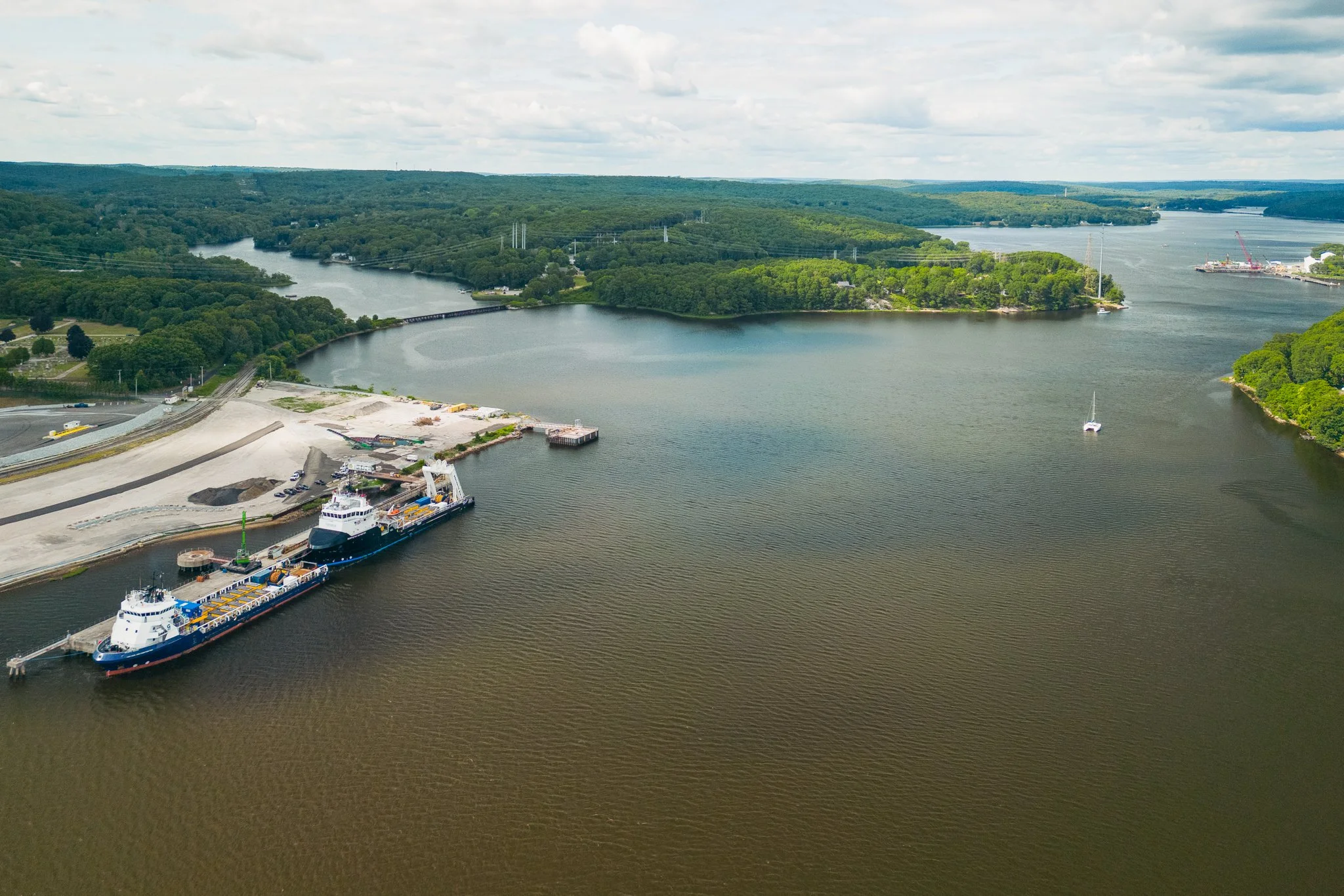 Aerial drone view looking up the Thames River past the docked Thayer Mahan vessels.