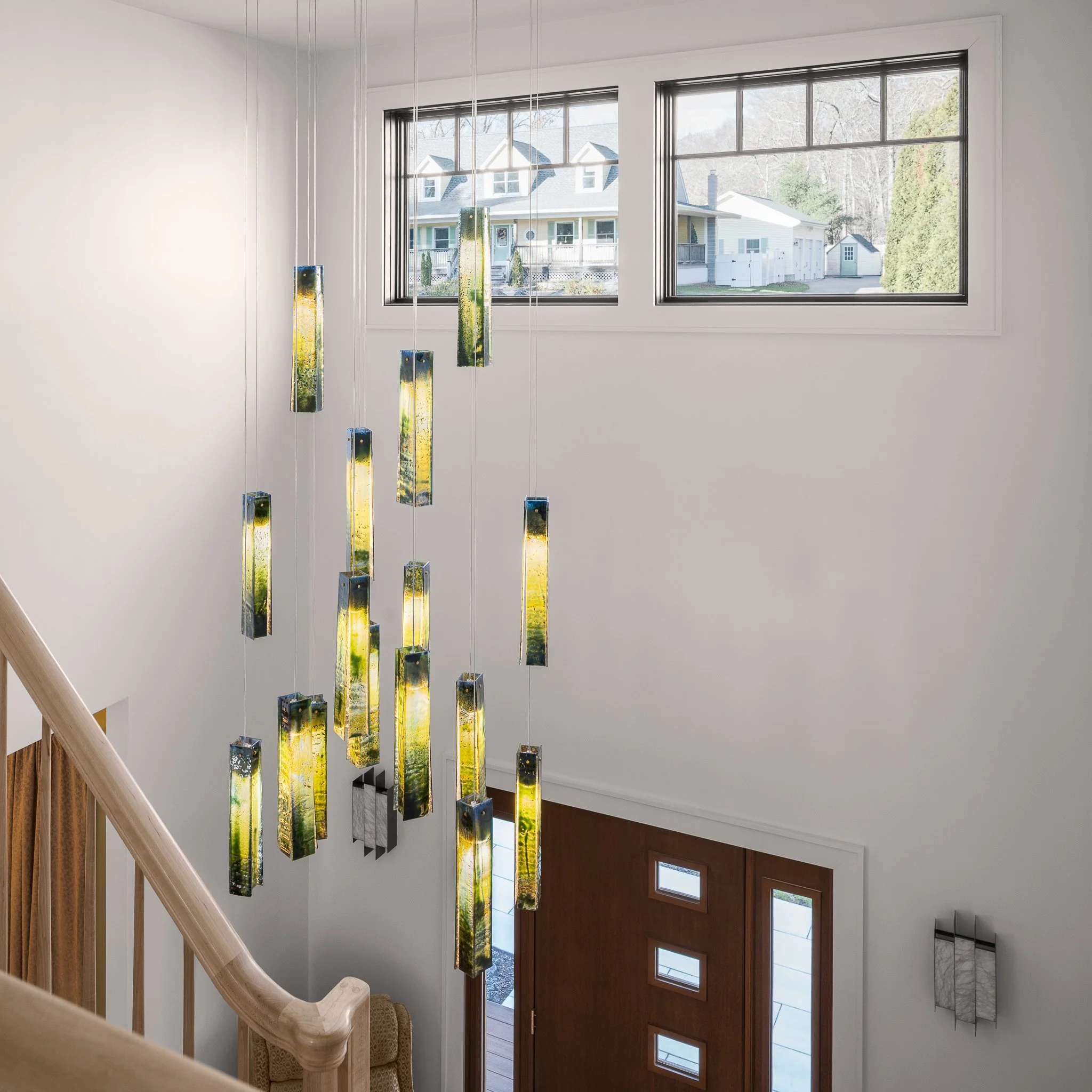 Two-story foyer seen from above with a cascading glass pendant chandelier.