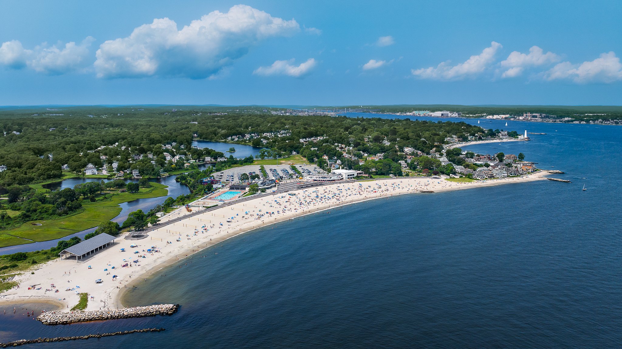 Aerial drone view of the curving sand at Ocean Beach Park with the Thames River beyond in New London, CT.
