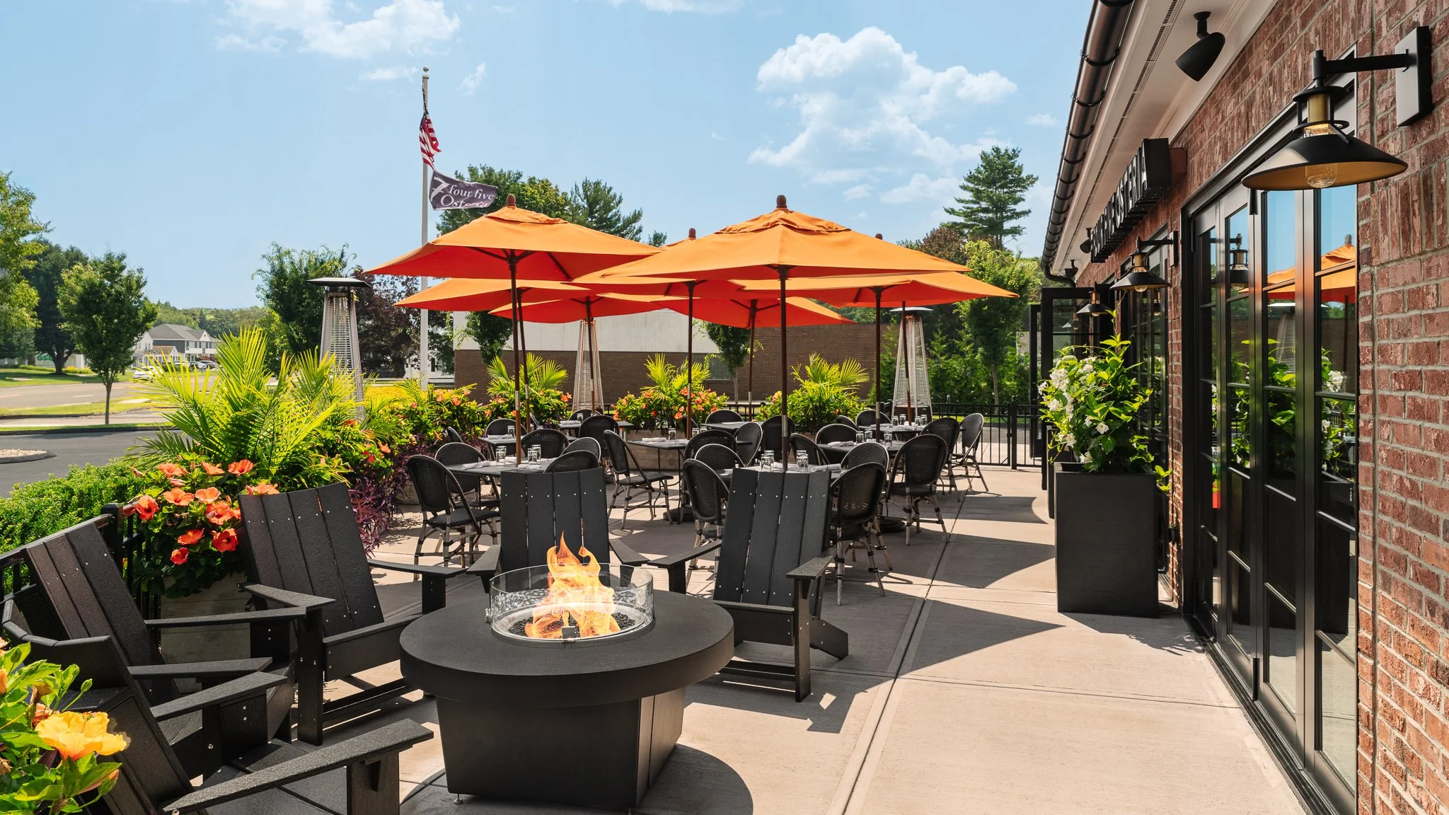 Outdoor patio at 745 Osteria with orange umbrellas and a fire pit.