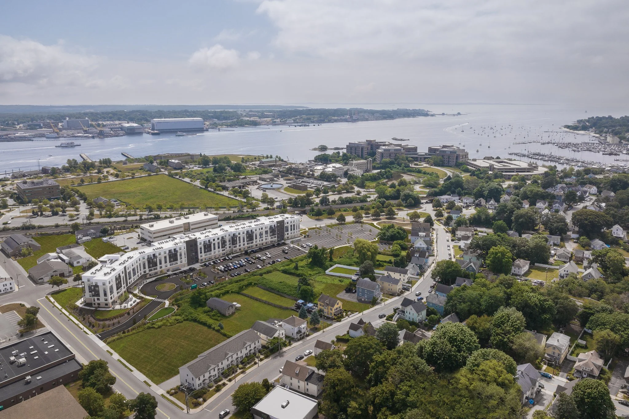 Aerial drone view of The Beam apartments with the Thames River and Long Island Sound in the distance.