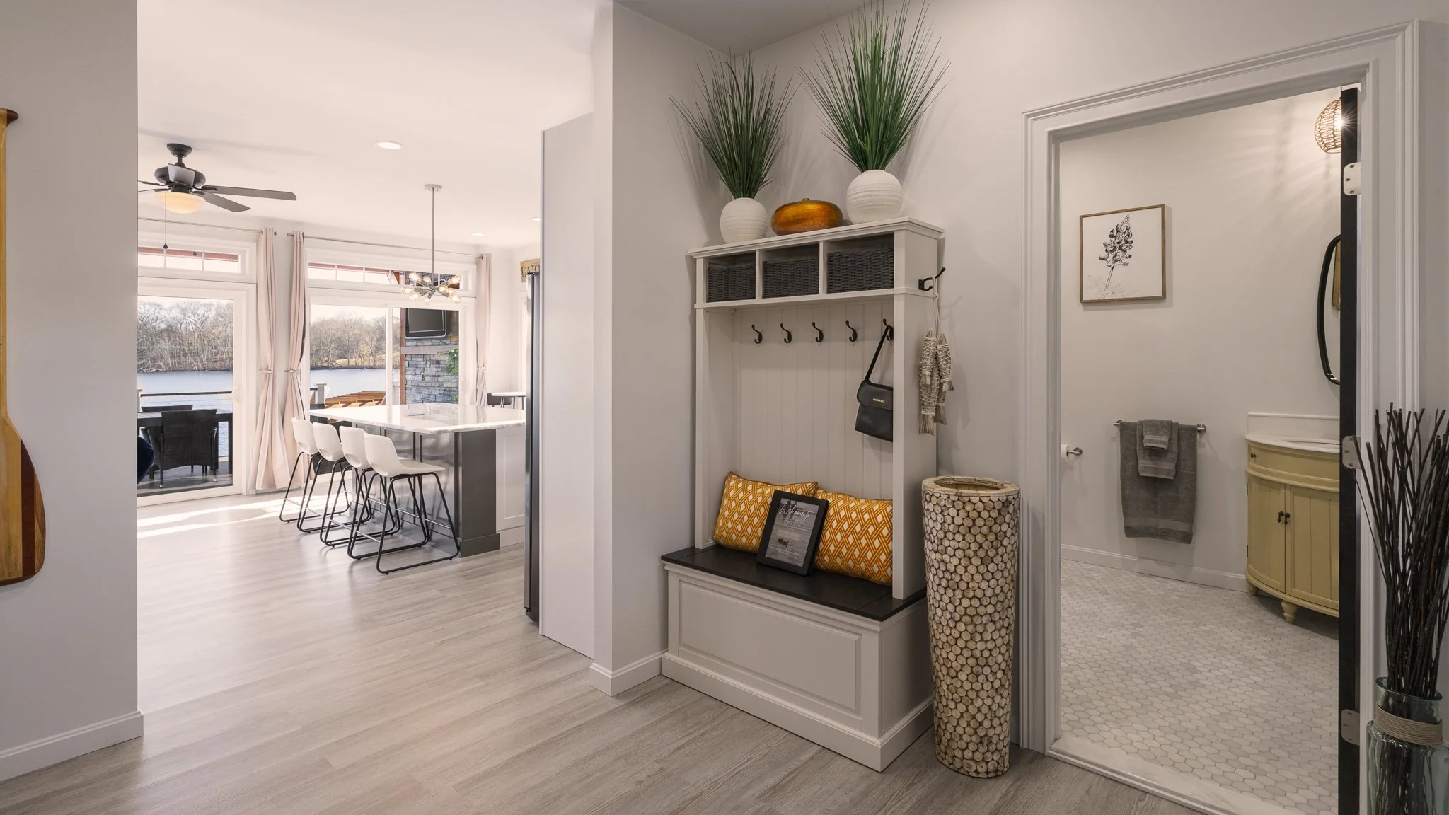 Entrance foyer with a storage bench and a view into the kitchen.