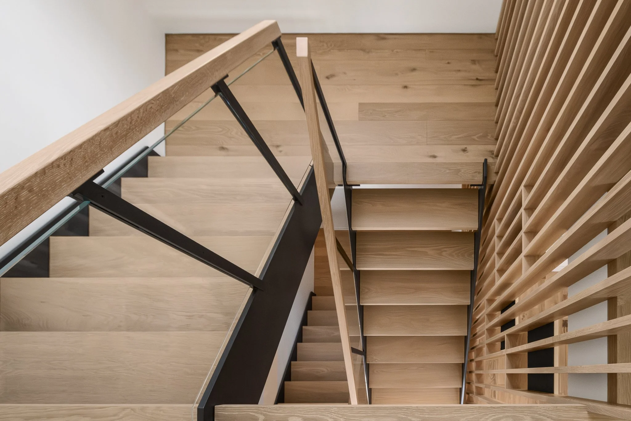 Looking down the open wood staircase past the vertical slats.