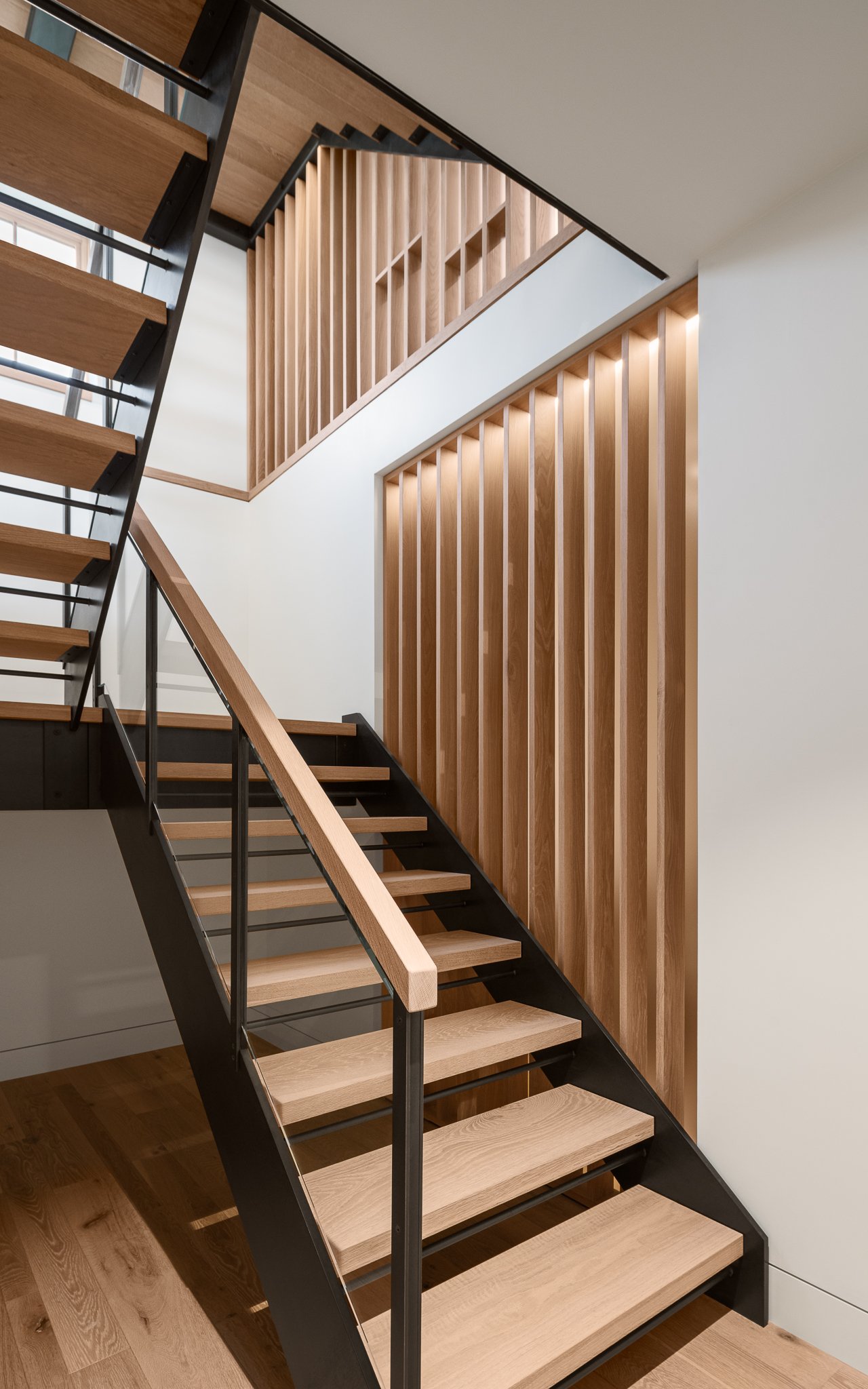Wood stair and slat wall rising from the lower level.