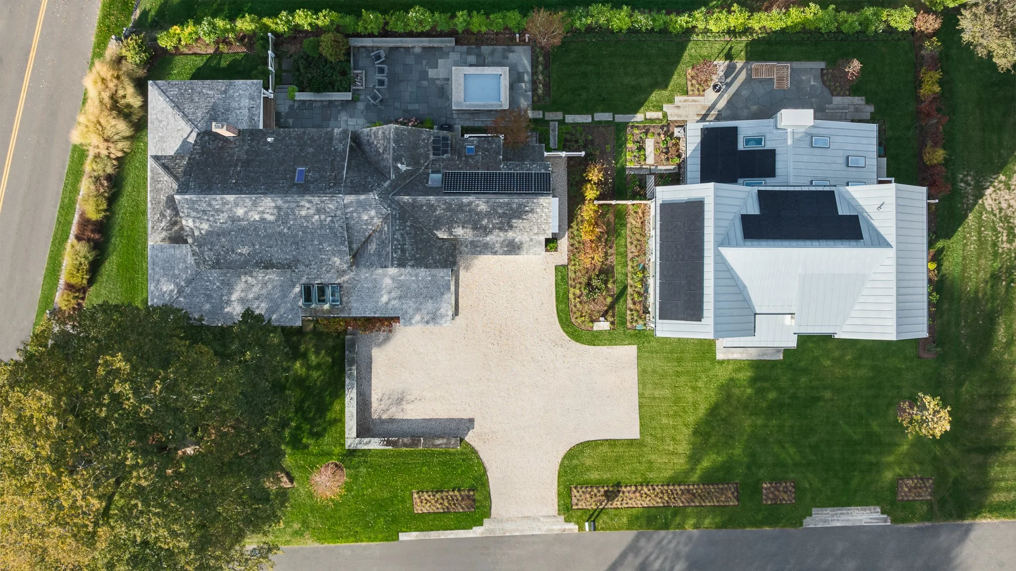 Overhead aerial drone view of both houses, the gravel drive and the walkways that connect them.