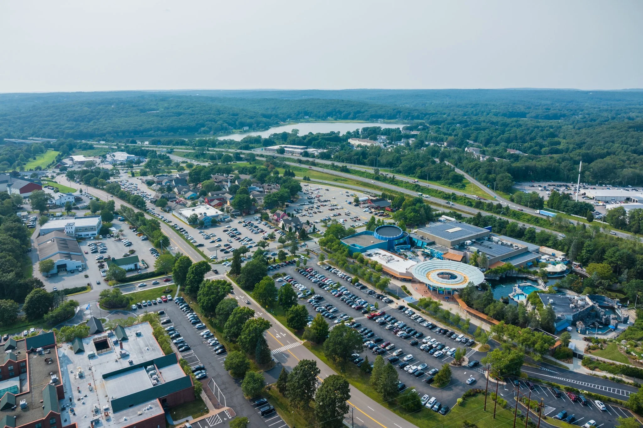 Aerial drone view of the shopping center with Mystic Aquarium nearby.