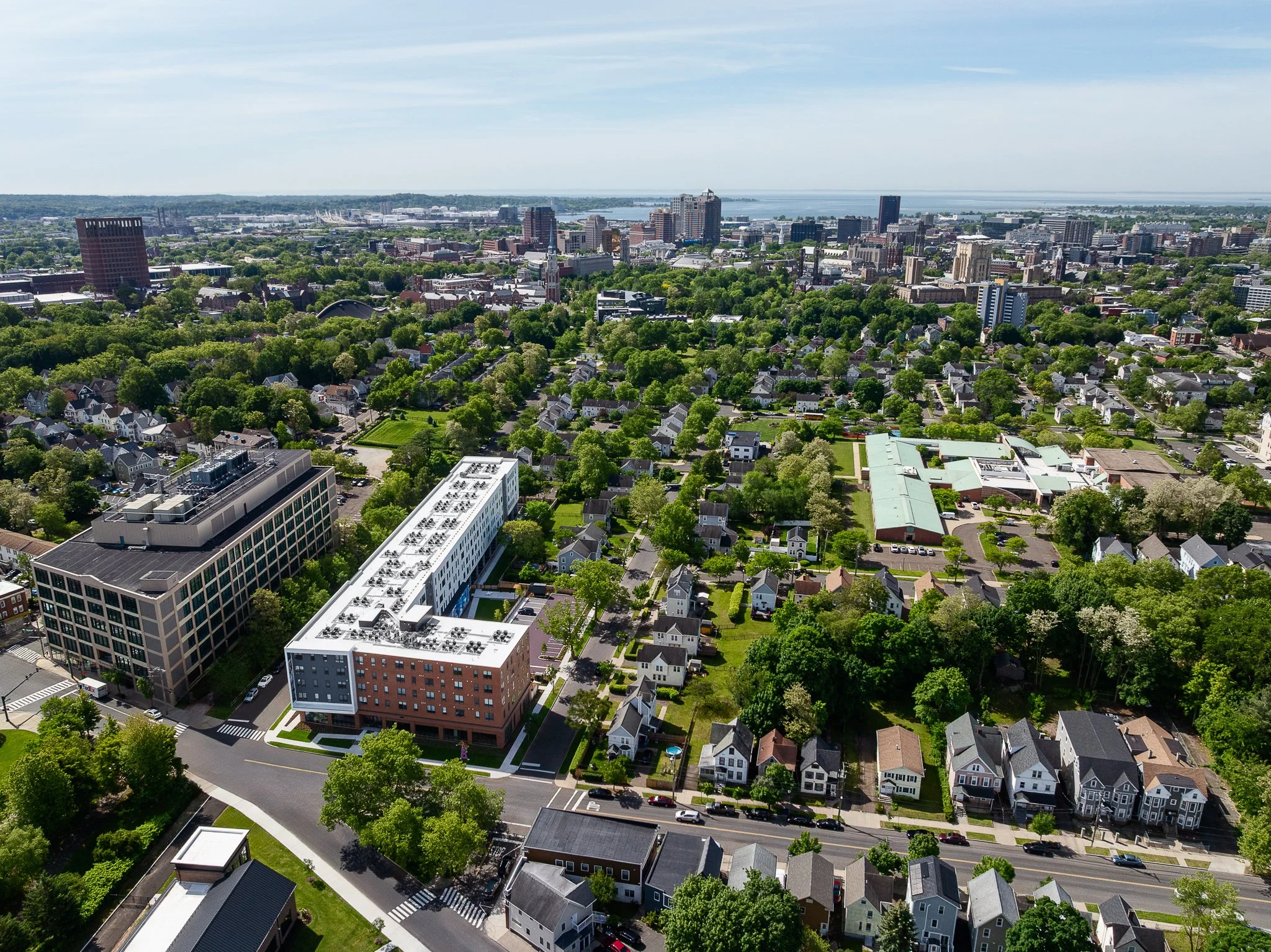 Aerial drone view of Cadence on Canal with the downtown New Haven skyline and Long Wharf beyond.