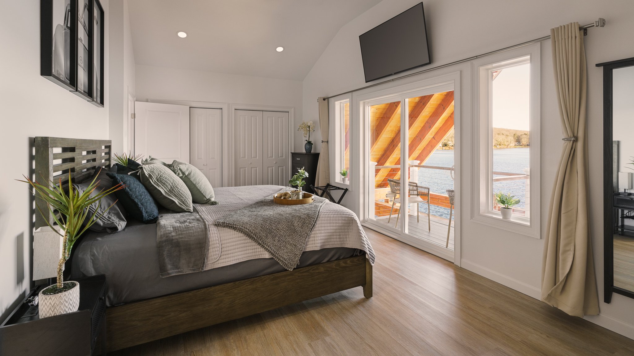 Primary bedroom with glass doors looking out to the lake.