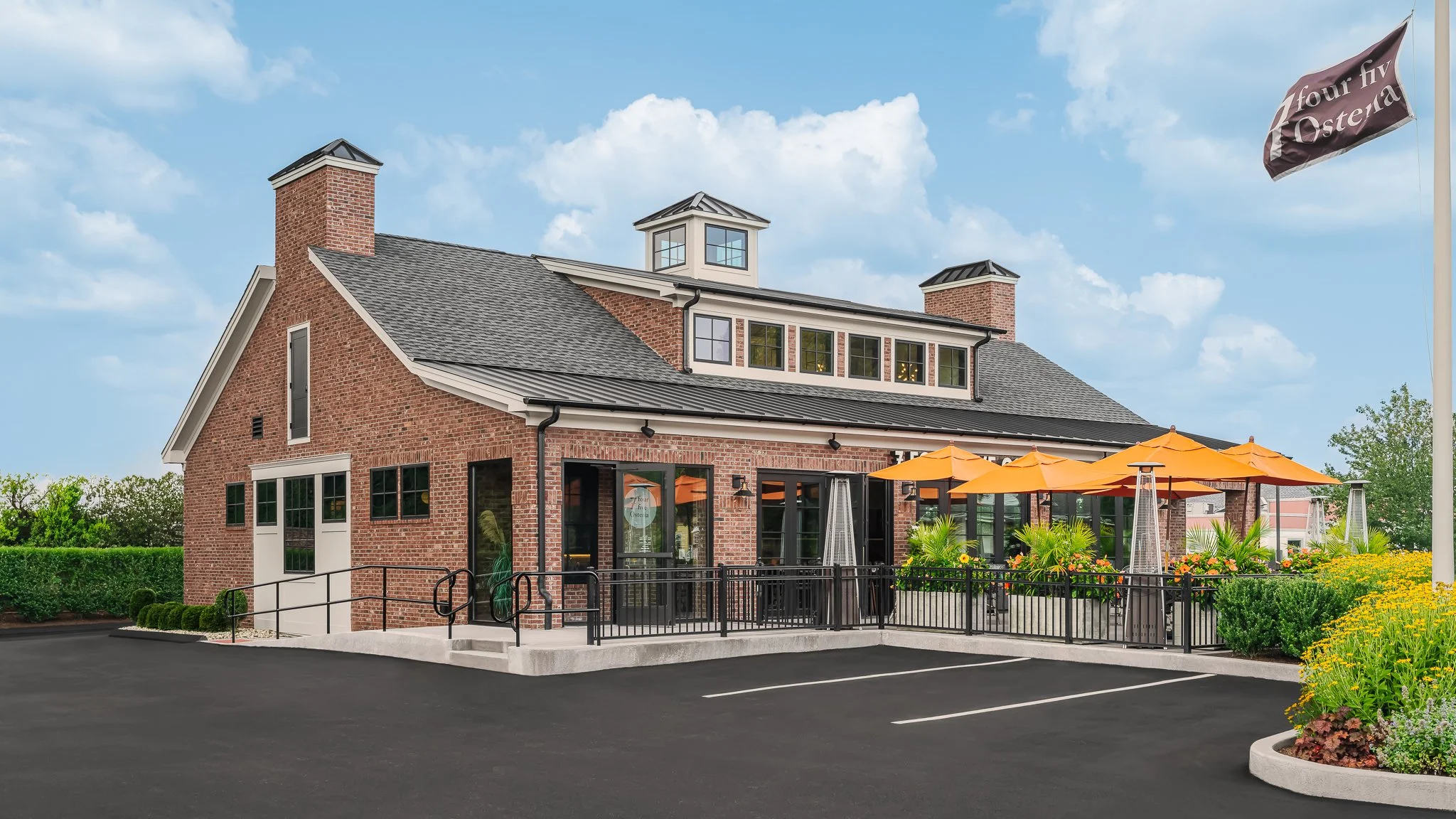 Brick restaurant exterior with a cupola and outdoor dining area.