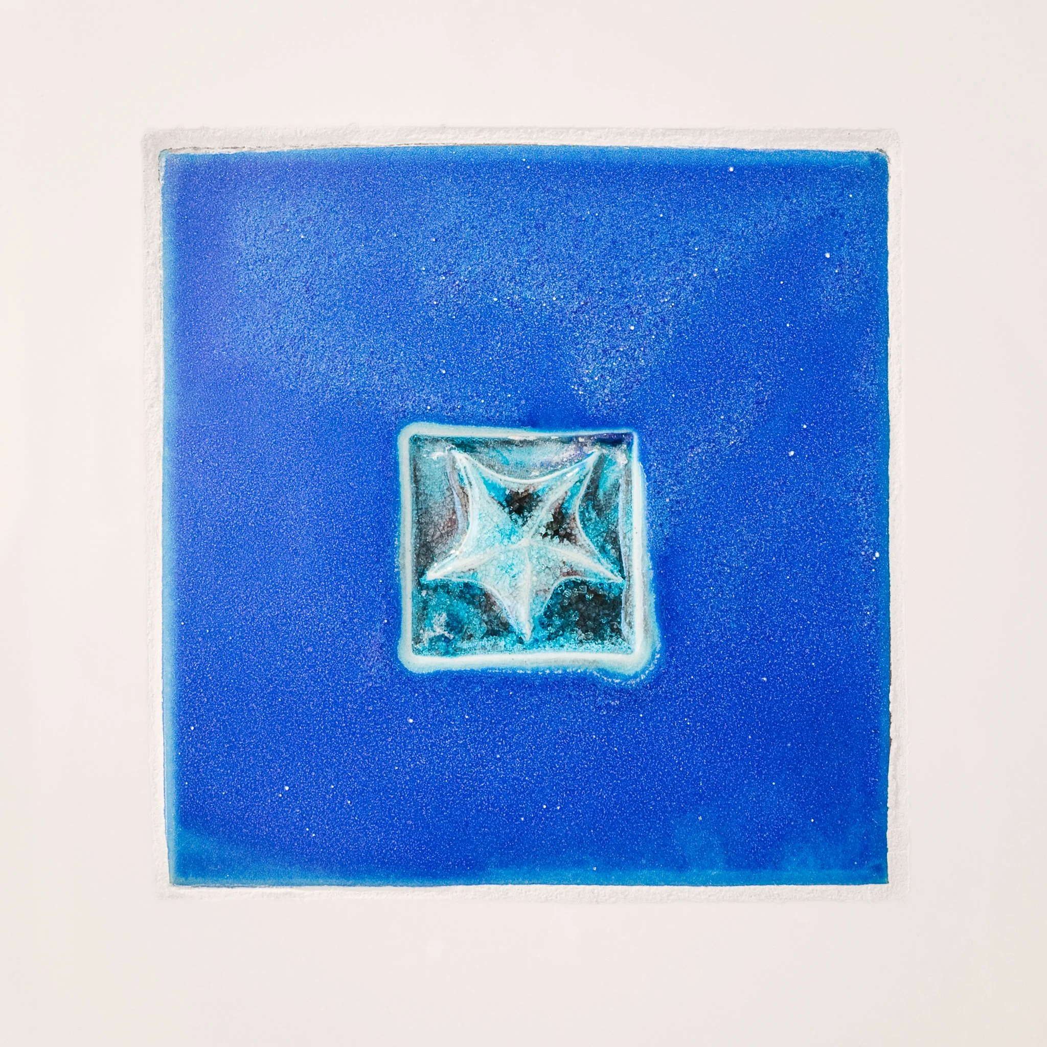 Handmade blue tile with a glass starfish inset.