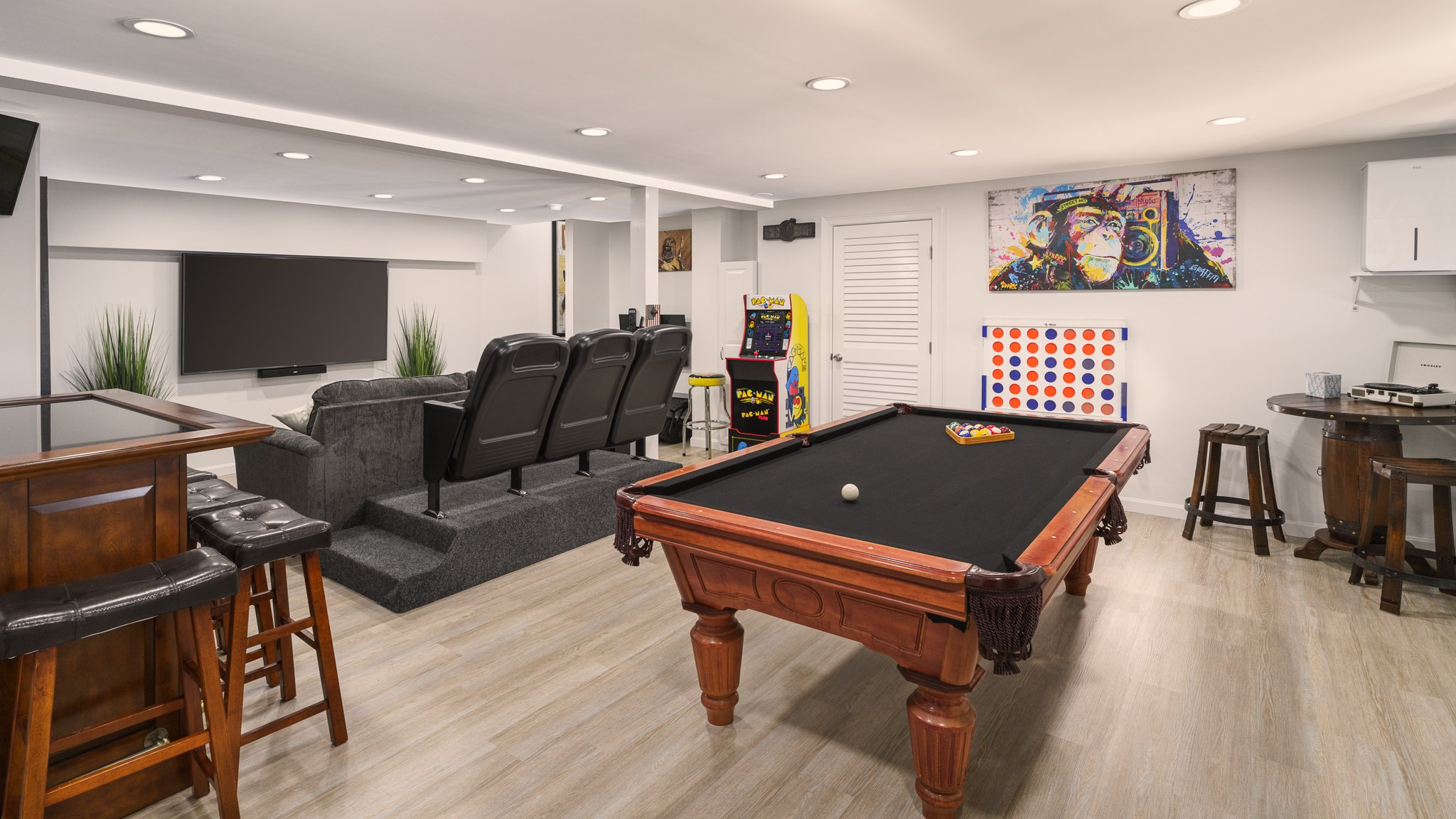 Basement game room with a pool table and TV lounge.