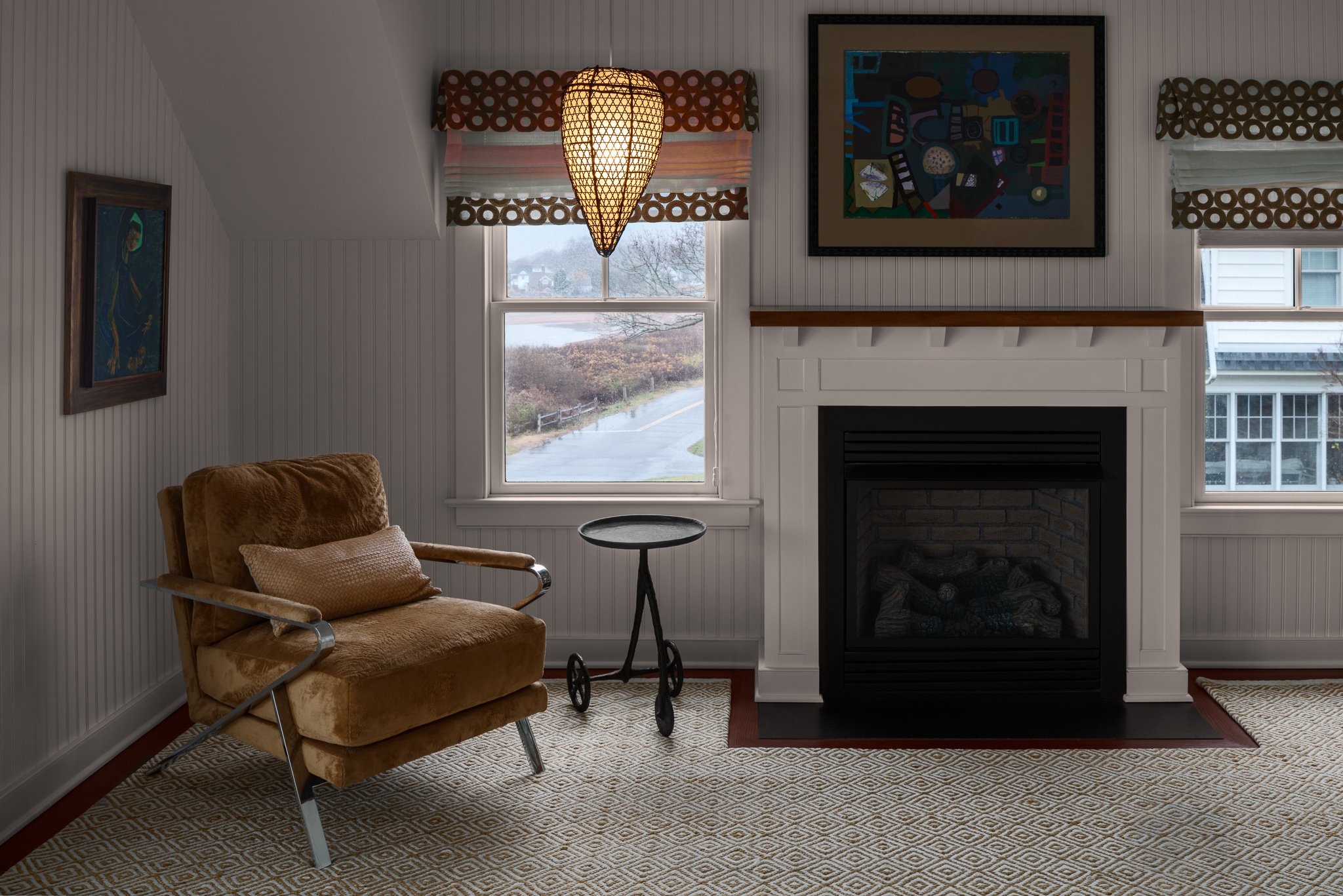 Bedroom fireplace corner with a reading lamp and shoreline windows.