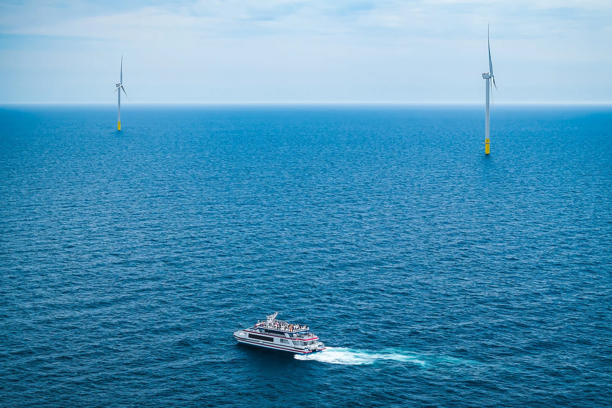 Cross Sound Ferry's Cecelia Ann crossing open water between two distant wind turbines.
