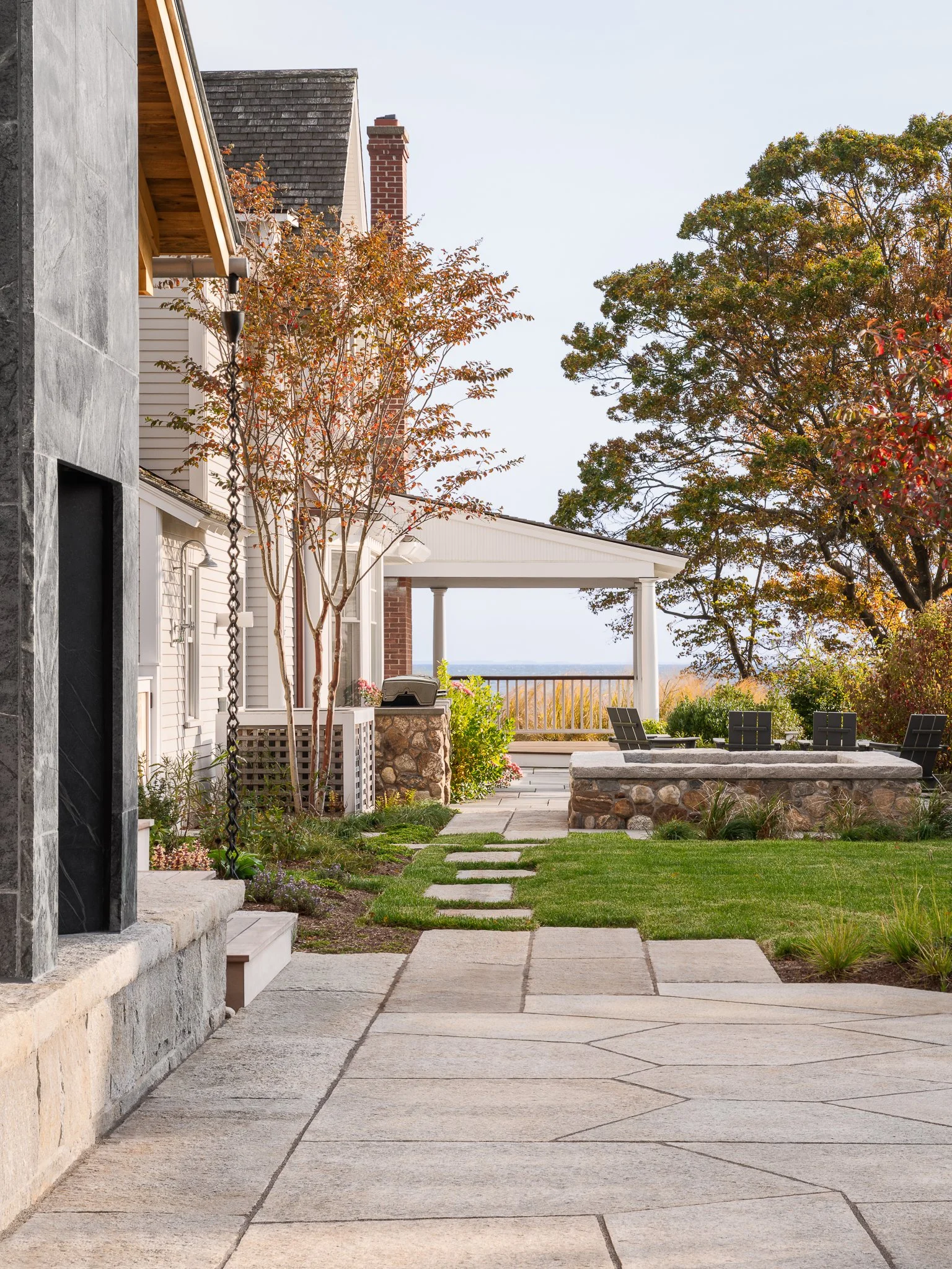Stone path along the side of the guest house leading toward the main house and the water.