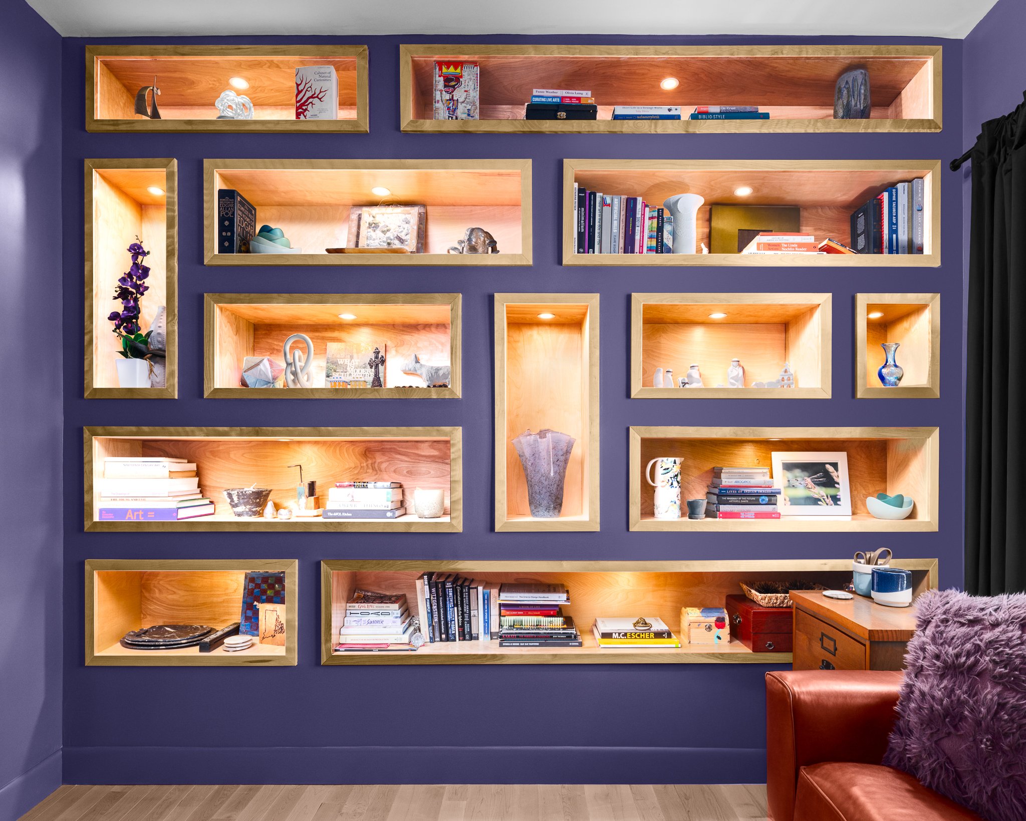Backlit display shelves built into a purple wall.