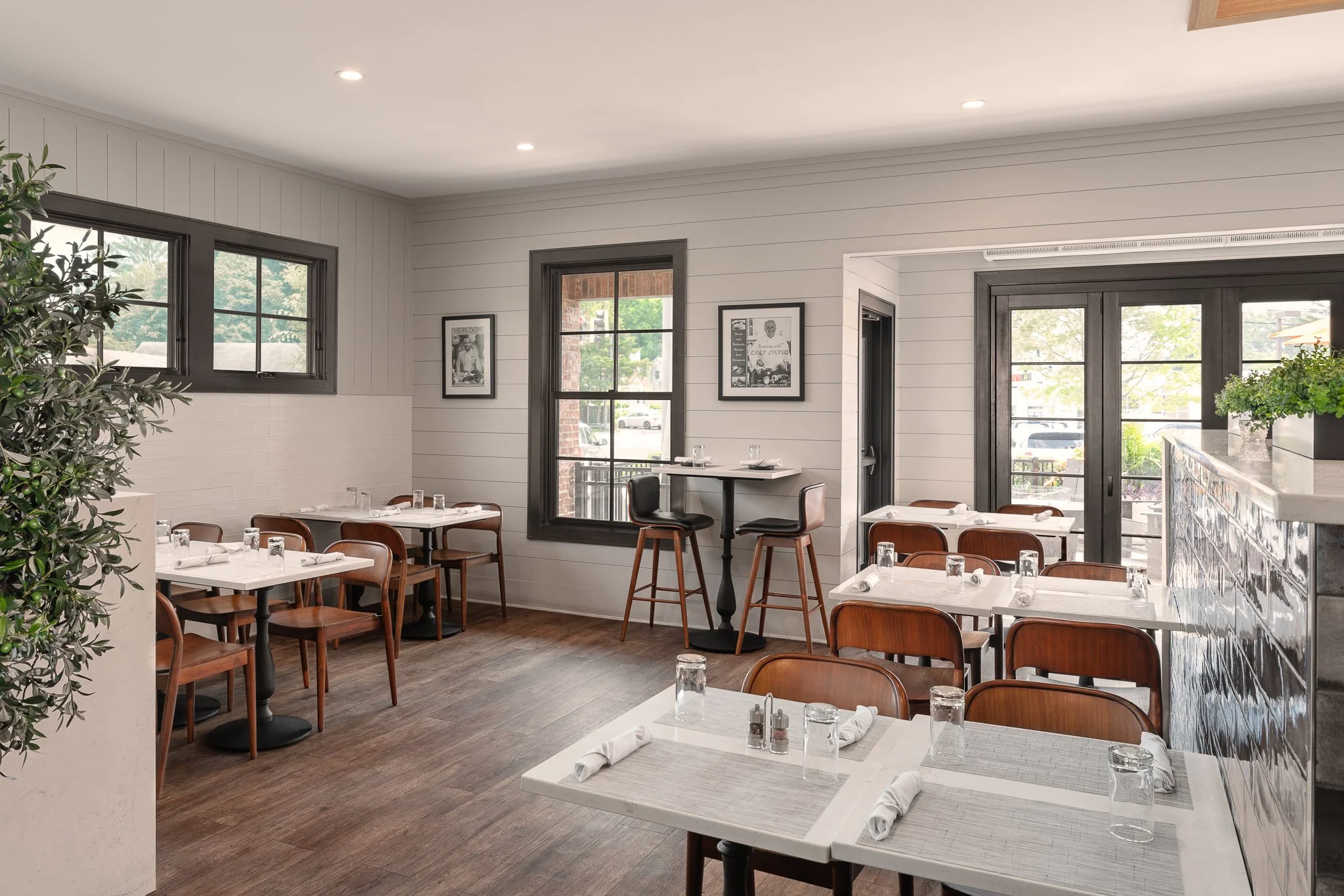 Side dining area with window tables and dark trimmed windows.