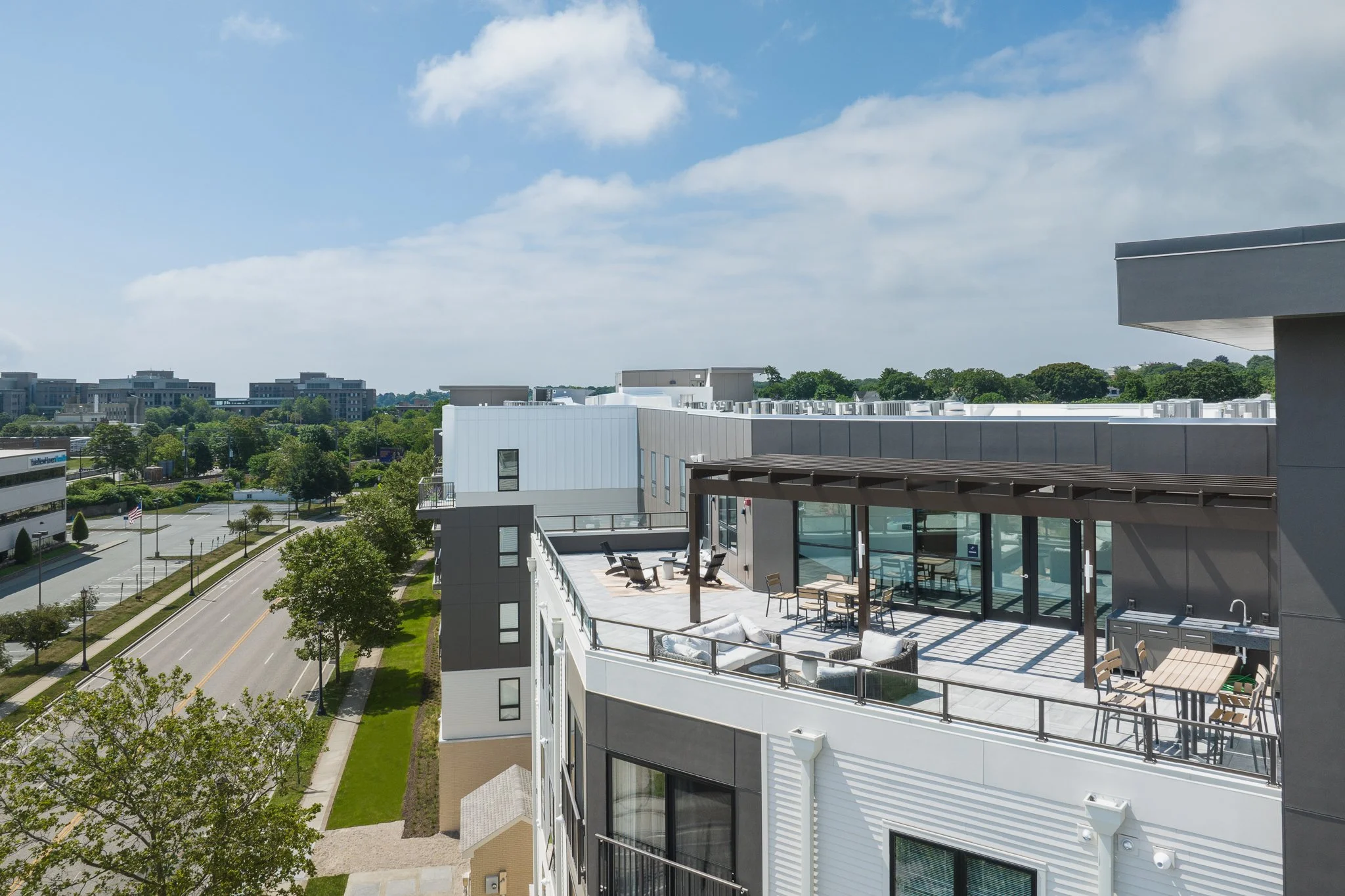 Aerial drone view of a rooftop balcony with outdoor seating.
