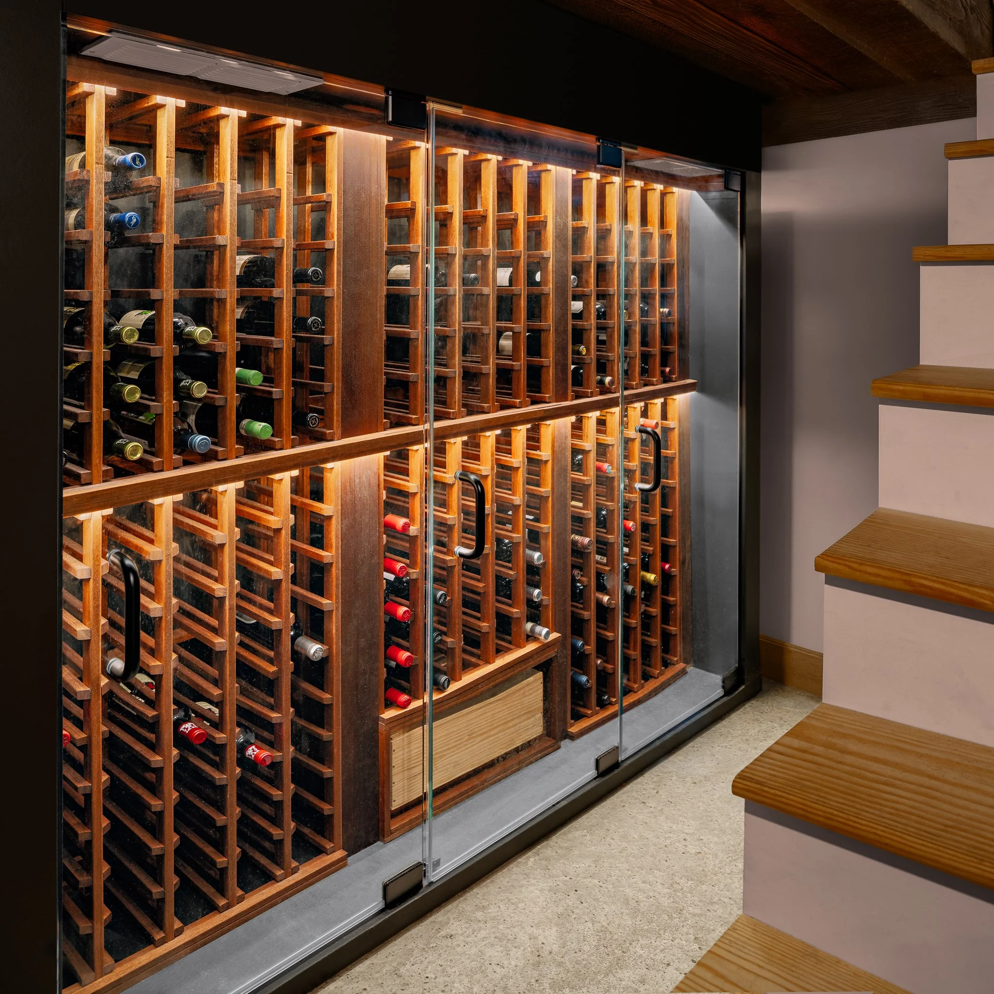 Wine cellar racks at the foot of the basement stairs.