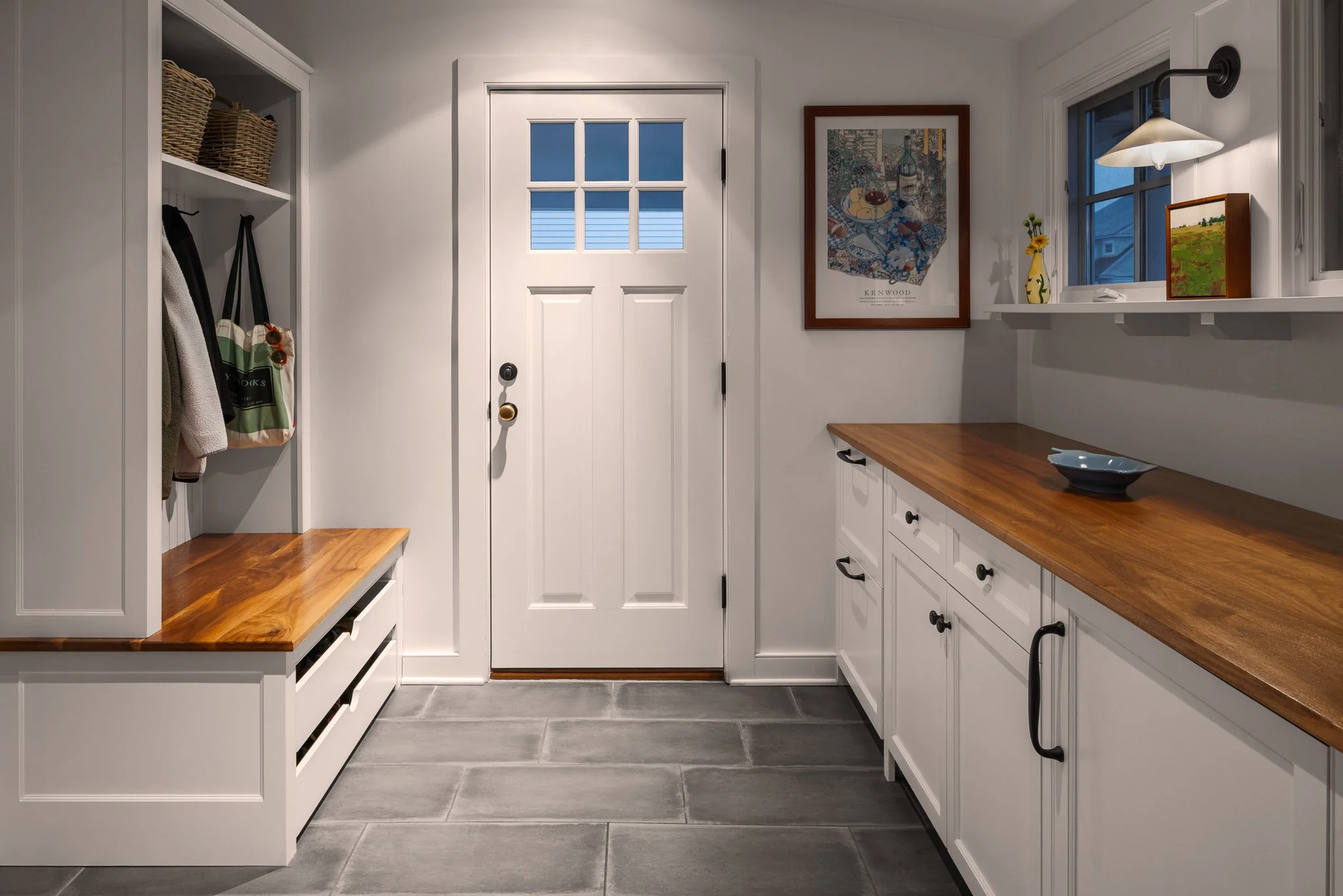 Mudroom entry with wood counters, a coat rack and stone tile floor.