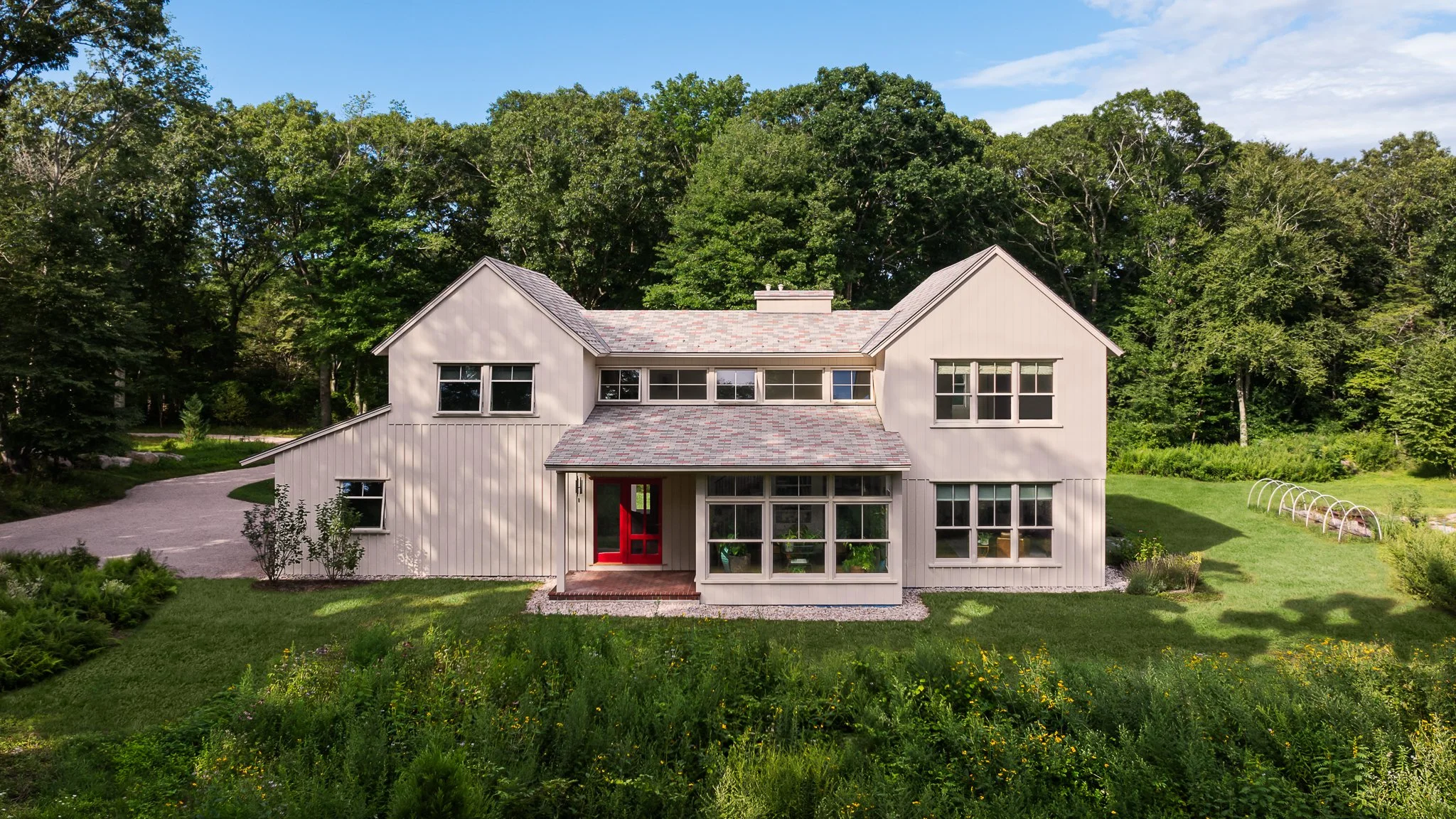 Aerial drone view of the rear elevation and wildflower backyard.