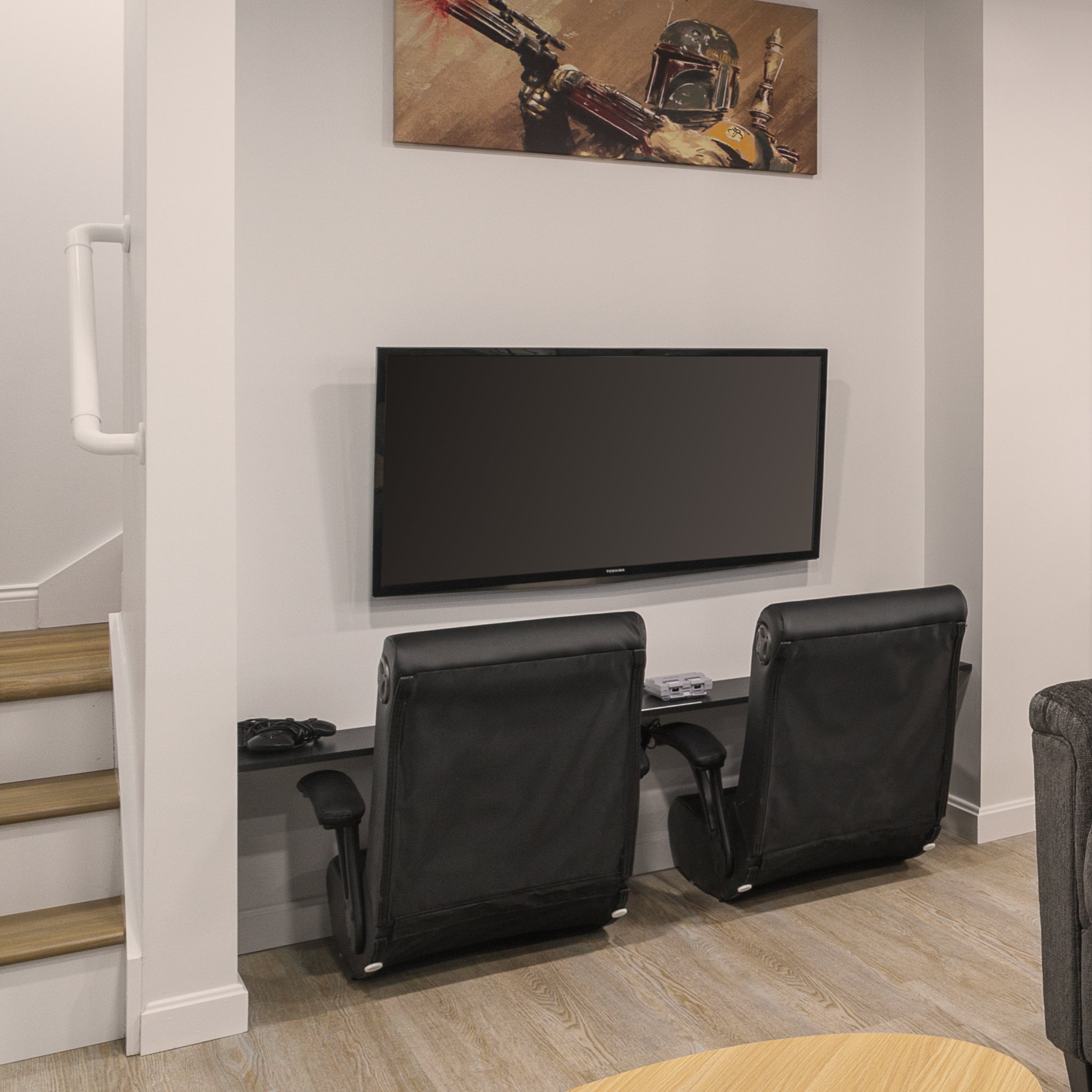 Gaming corner with two recliners and a wall-mounted TV.
