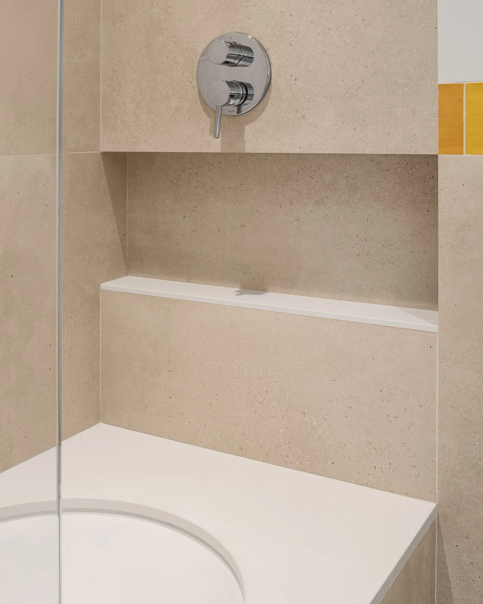 Recessed niche built into the tiled tub surround.