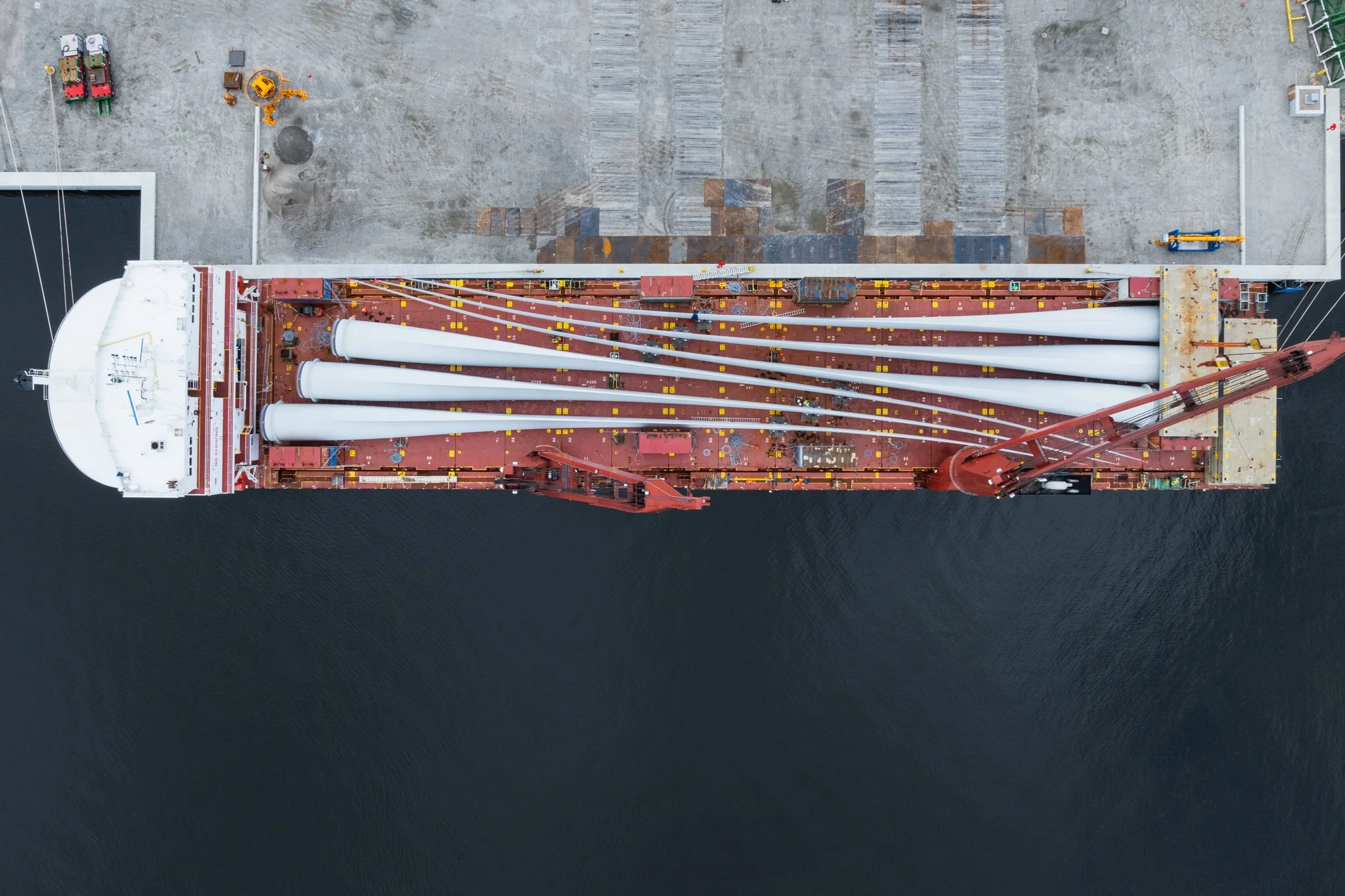 Top-down aerial drone view of a ship loaded with wind turbine components.