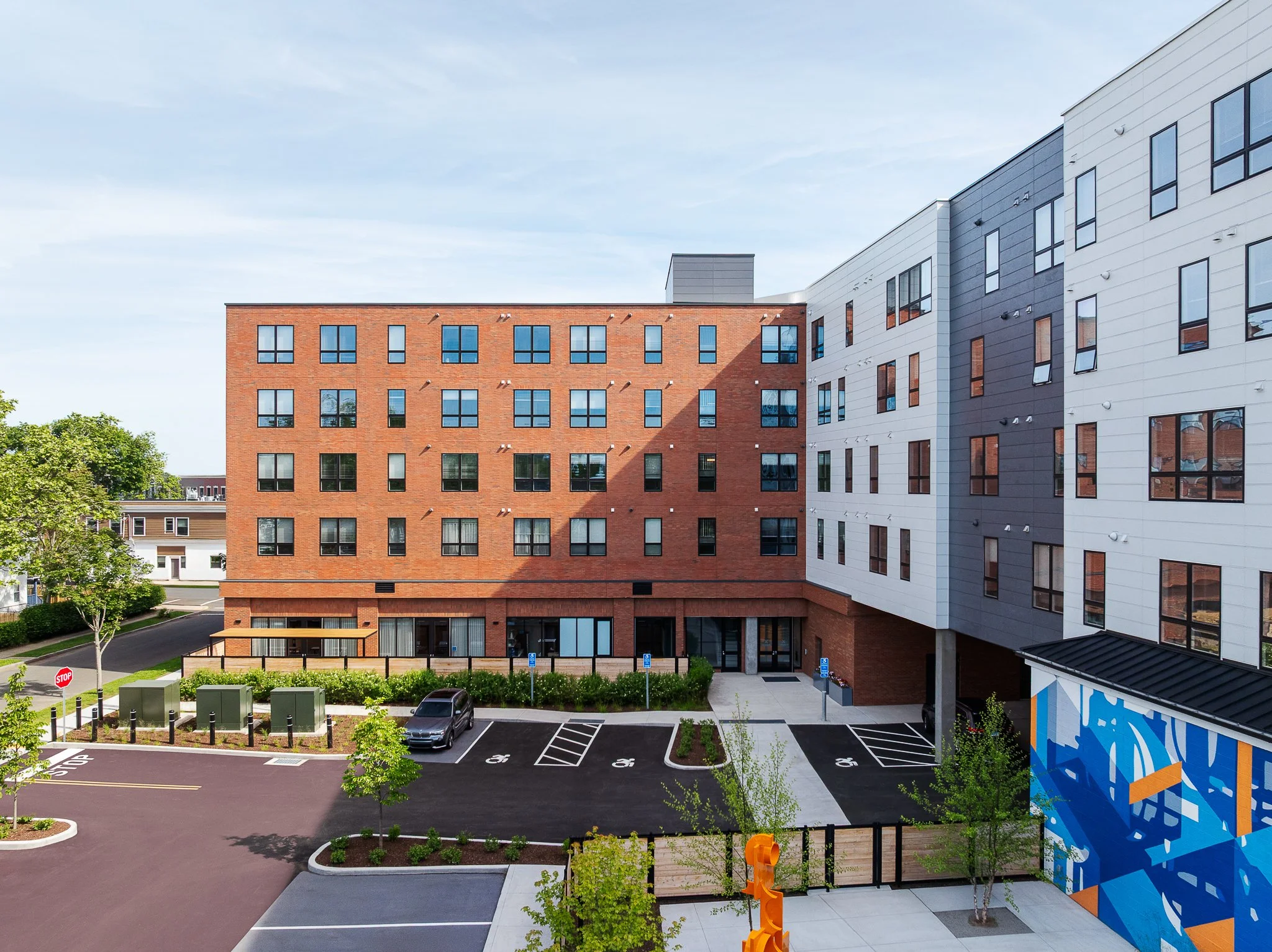 Rear parking lot and entrance with the courtyard mural on the right.