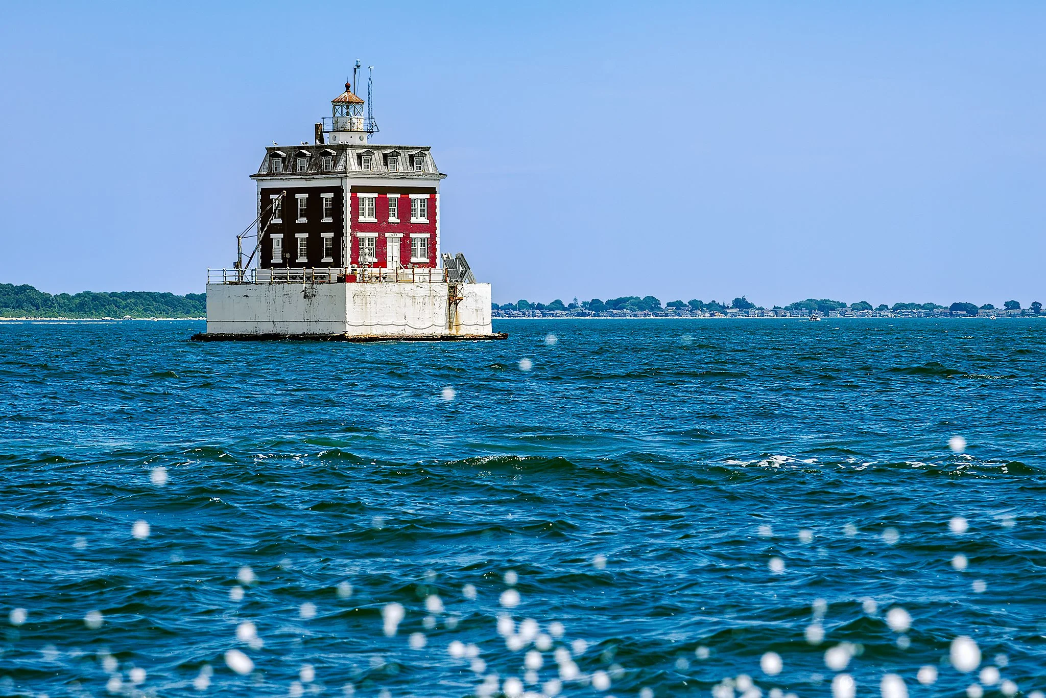 New London Ledge Light at the mouth of the Thames River in New London, CT, rising from choppy blue water.