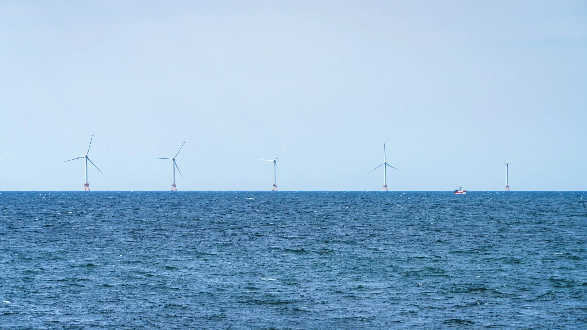 Block Island Wind Farm's five turbines on lattice foundations along the horizon.