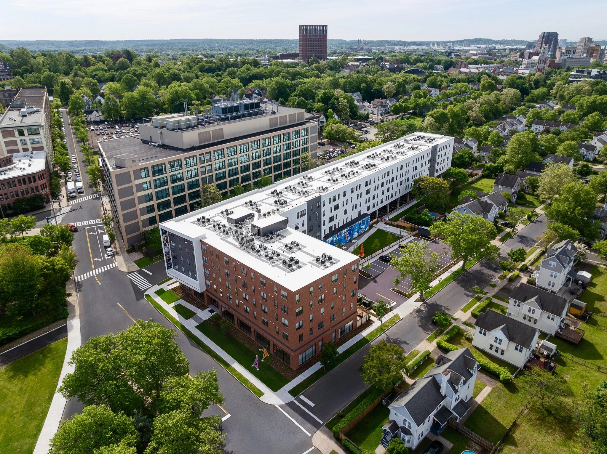 Aerial drone view down the street past the entrance to the rear parking lot.