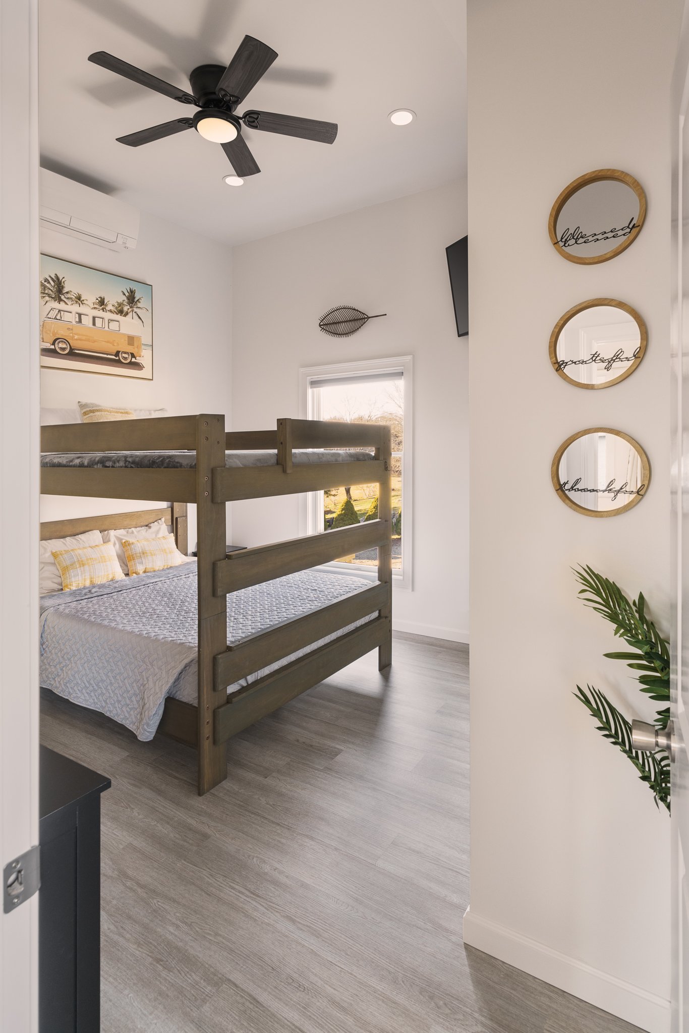 Bedroom with wooden bunk beds and a ceiling fan.