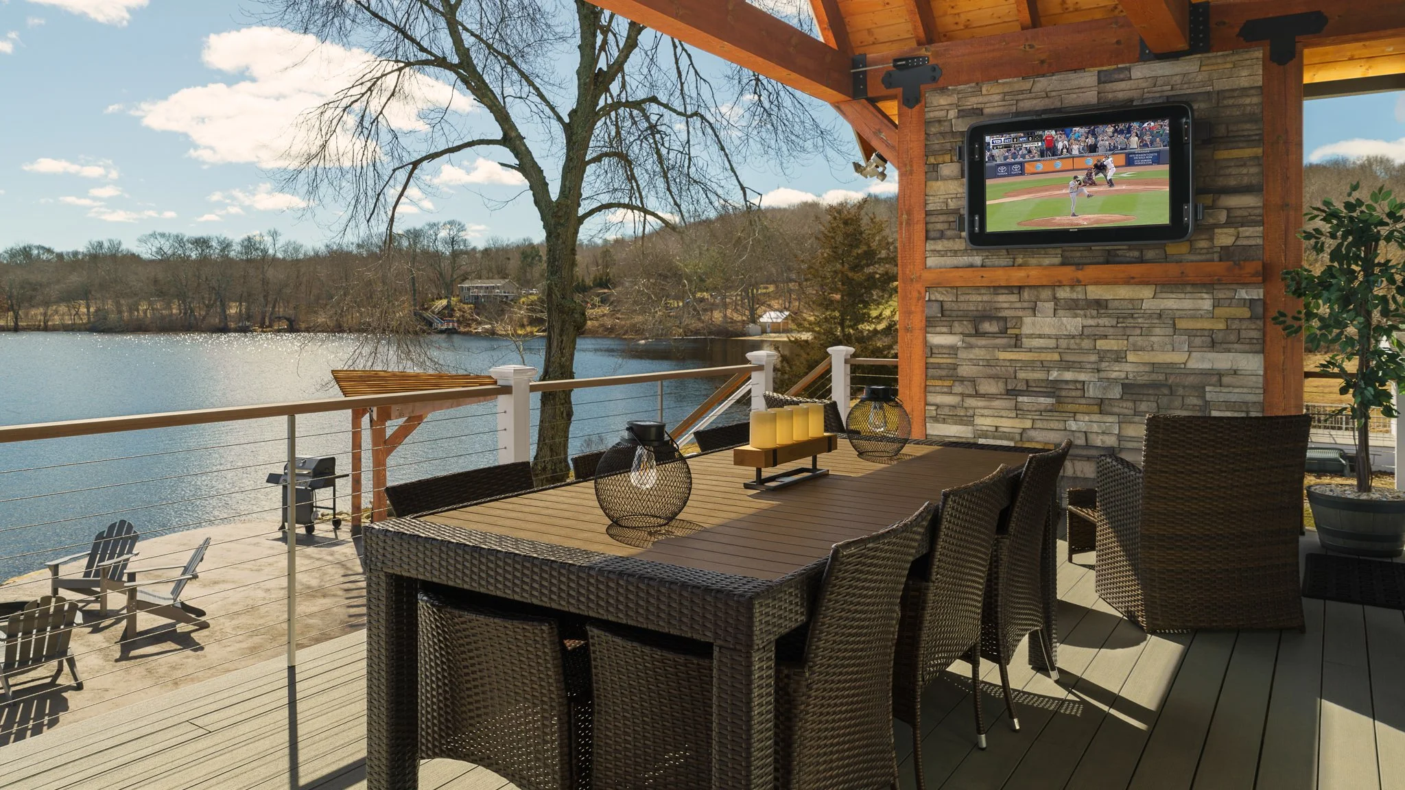 Covered back deck at the Eagles Nest Airbnb with an outdoor TV, dining table and a view of Amos Lake.