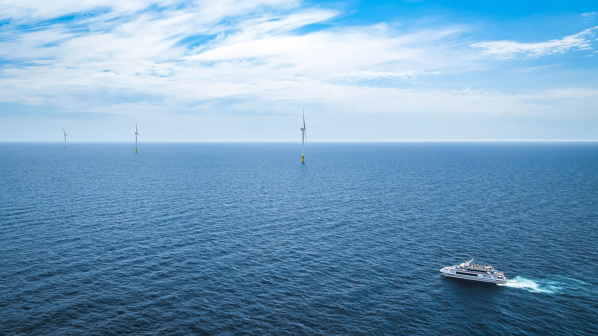 Cross Sound Ferry's Cecelia Ann in the foreground with three wind turbines along the horizon.