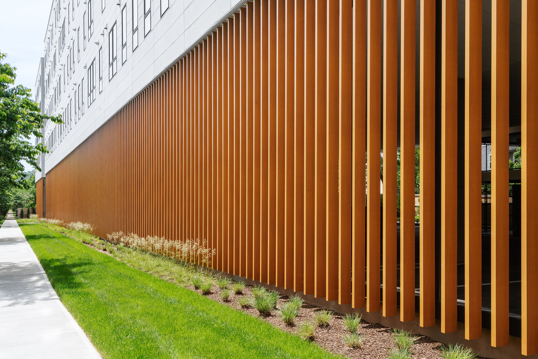 Tall wood slats screening the parking level along the length of the building.