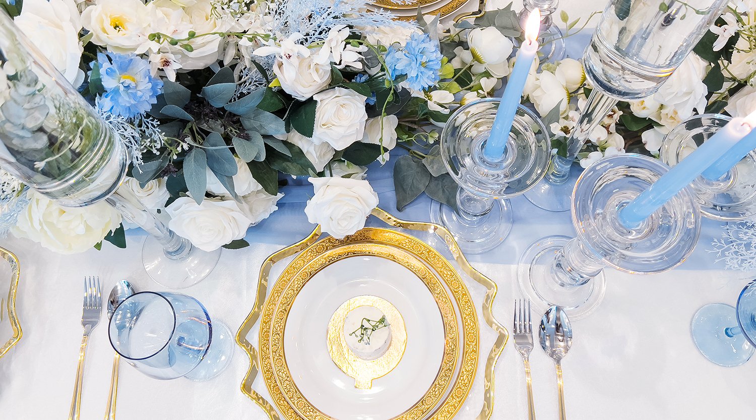 Elevate your wedding ambiance with elegant charger plates and slender candles, casting a romantic glow that captivates guests and adds enchantment.