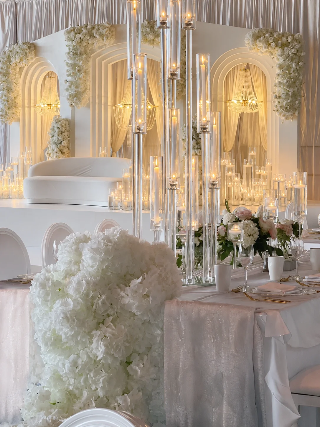 Elegant crystal candelabra with multiple taper candles, surrounded by floral arrangements and soft lighting, perfect for luxury wedding décor inspiration.