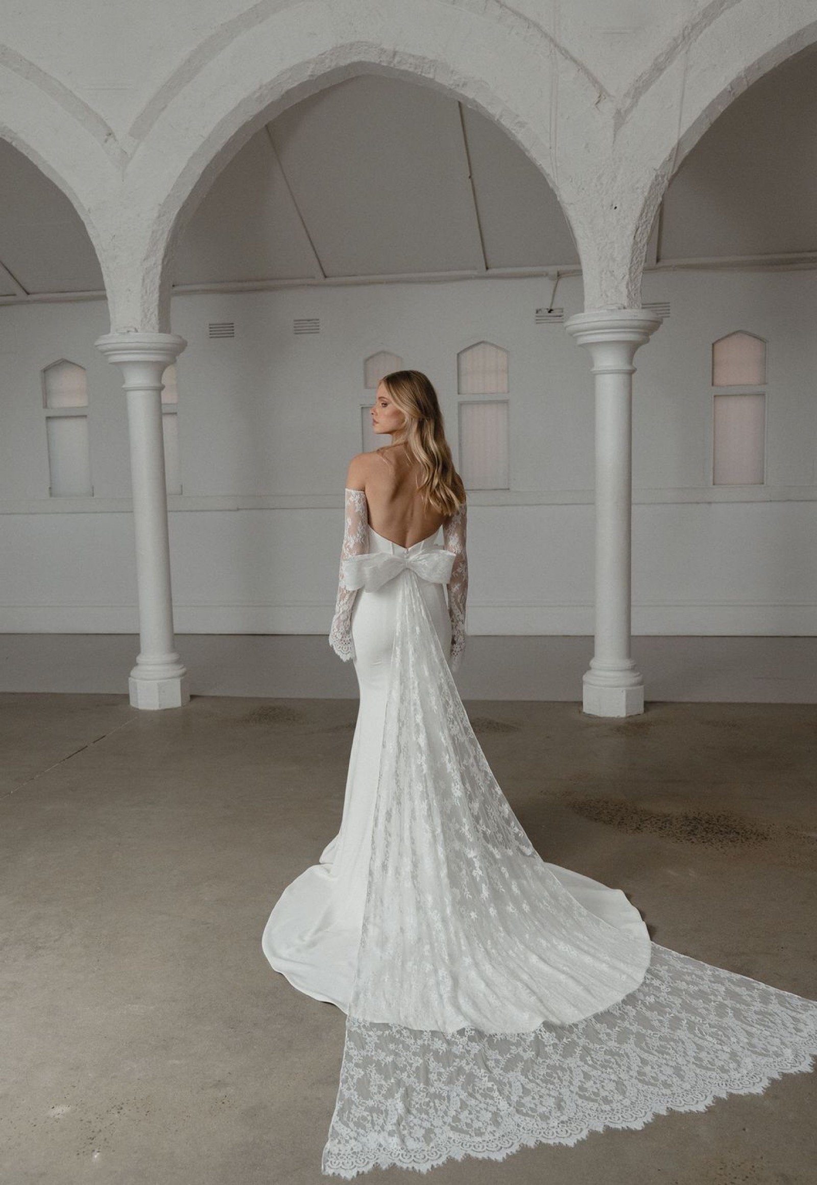     Lange Savoy-Spitzenschleppe mit dramatischer Wirkung am Fit-and-Flare-Brautkleid von Madi Lane