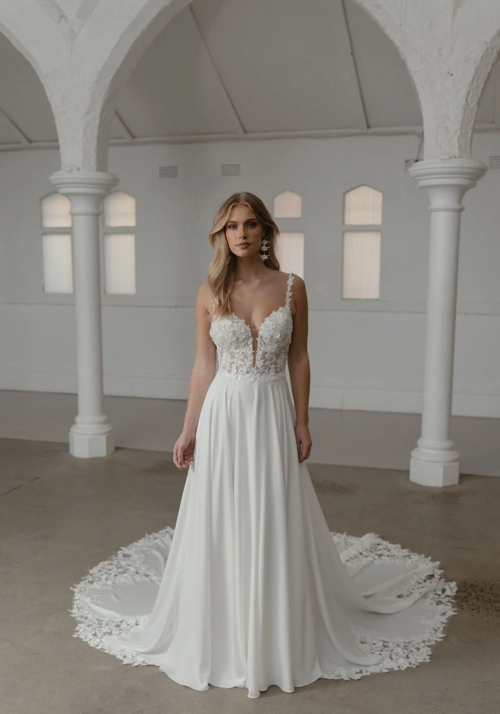     Somerset von Madi Lane – minimalistisches A-Linien-Brautkleid mit fließendem Rock und Spitzenschleppe