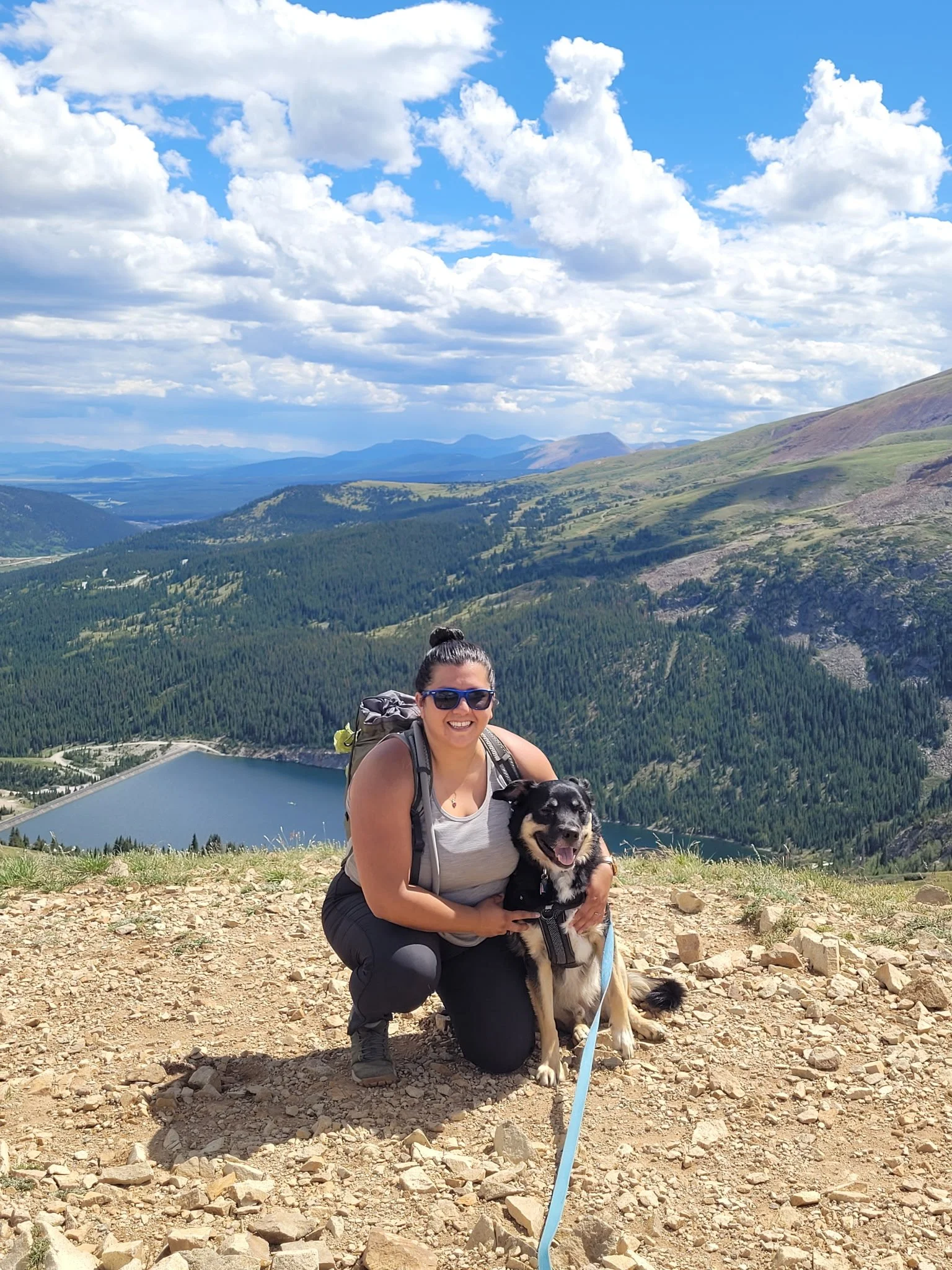 Landscape of mountainscape in CO in background, Nikki and her dog Bruno posing in foreground