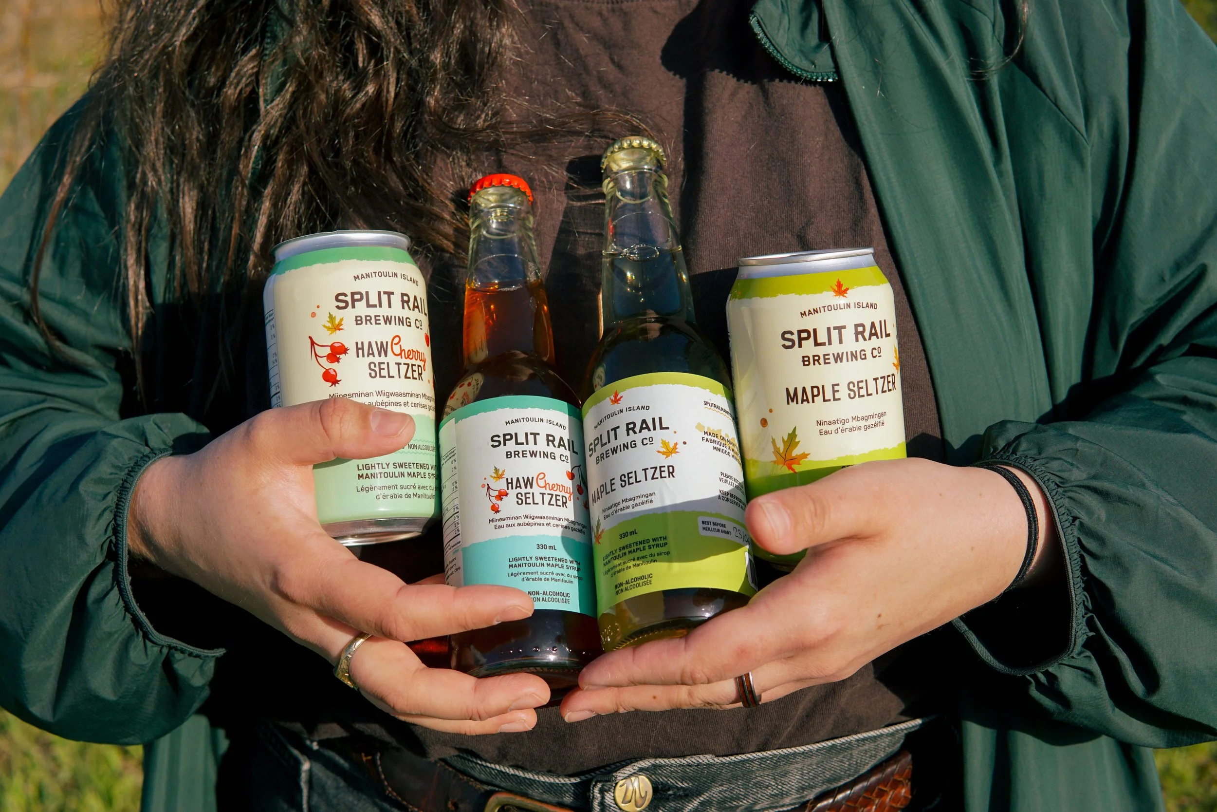 Katelyn holding Split Rail Seltzer cans and bottles.