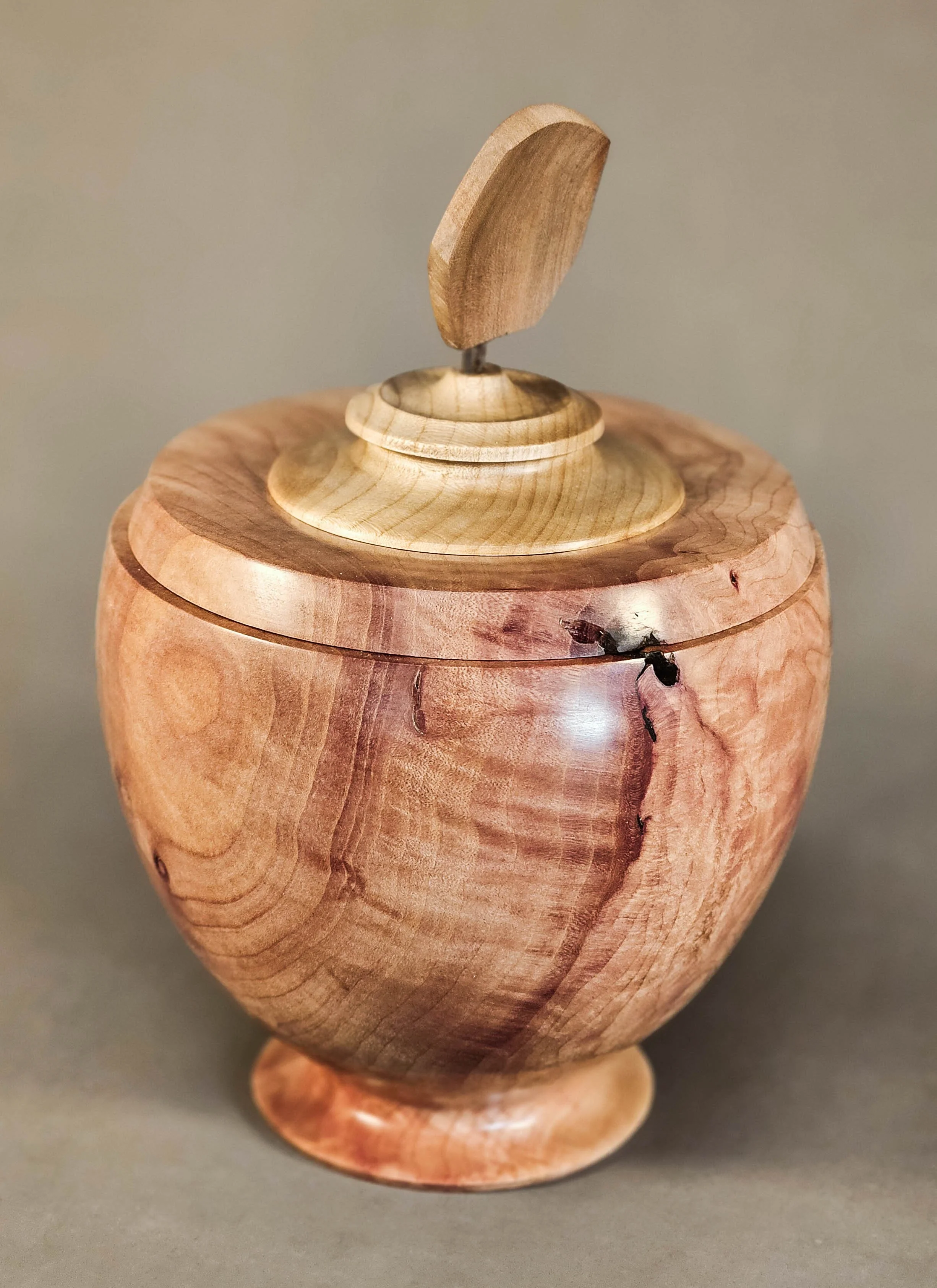 Lidded Madrone Vessel - Turned from a highly figured wood found at the base of a mature Madrone tree, this vessel showcases the wild, swirling grain of the wood. The raw material was salvaged from a tree lost to drought, preserving its unique charact