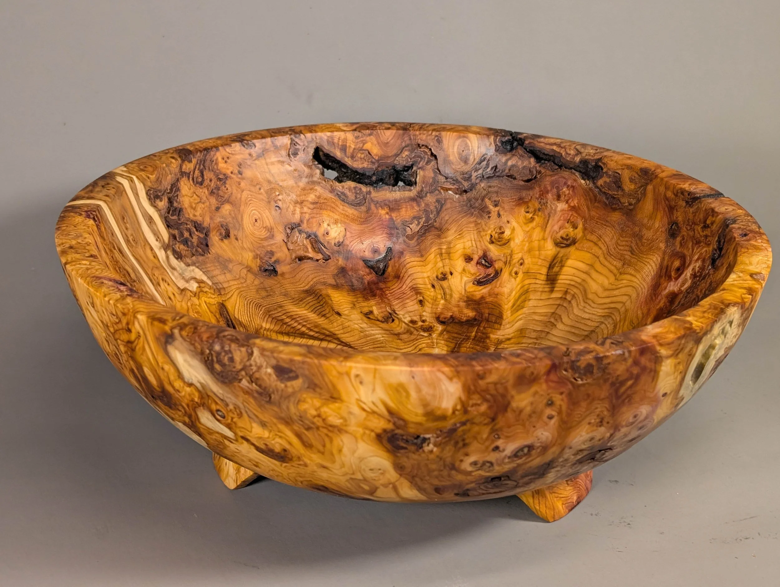 Salvaged Yew Root Bowl - Turned from the root burl of a Pacific Yew, this bowl showcases the extraordinary natural coloration—from deep amber to rich purples—inherent in the wood. The raw material was salvaged from a discarded root stock found on a r